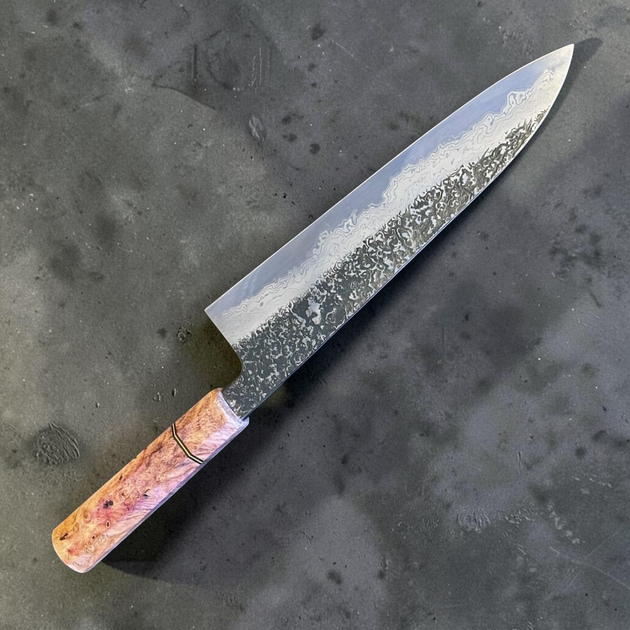 Masuda Yoshihide Blue #1 Kurozome Damascus Gyuto 210 mm with Prisma Knife custom handle, full angled profile showing the dark etched Damascus blade and warm figured handle.