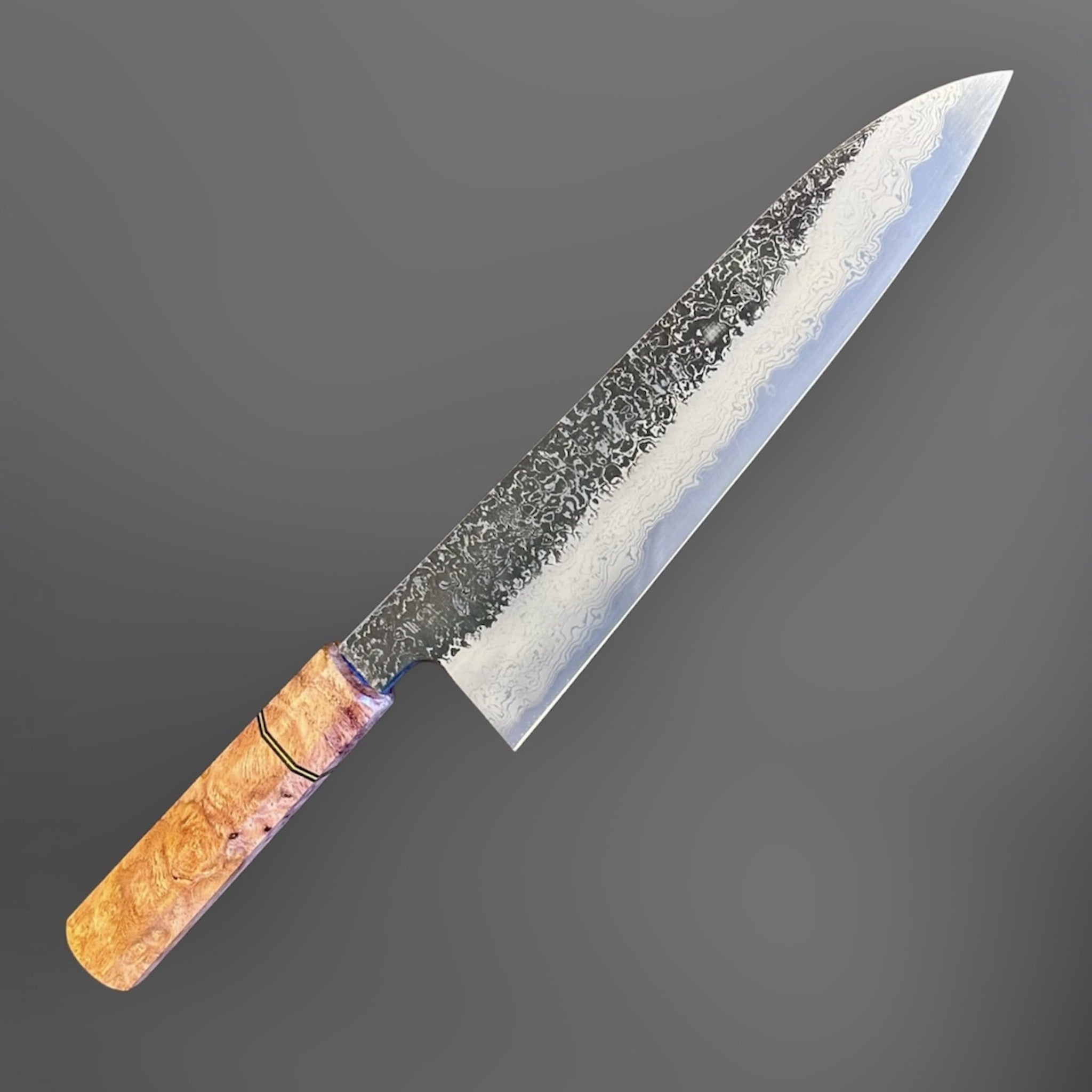 Masuda Yoshihide Blue #1 Kurozome Damascus Gyuto 210 mm with Prisma Knife custom handle, close angled view highlighting the kurozome Damascus pattern and pointed gyuto profile.