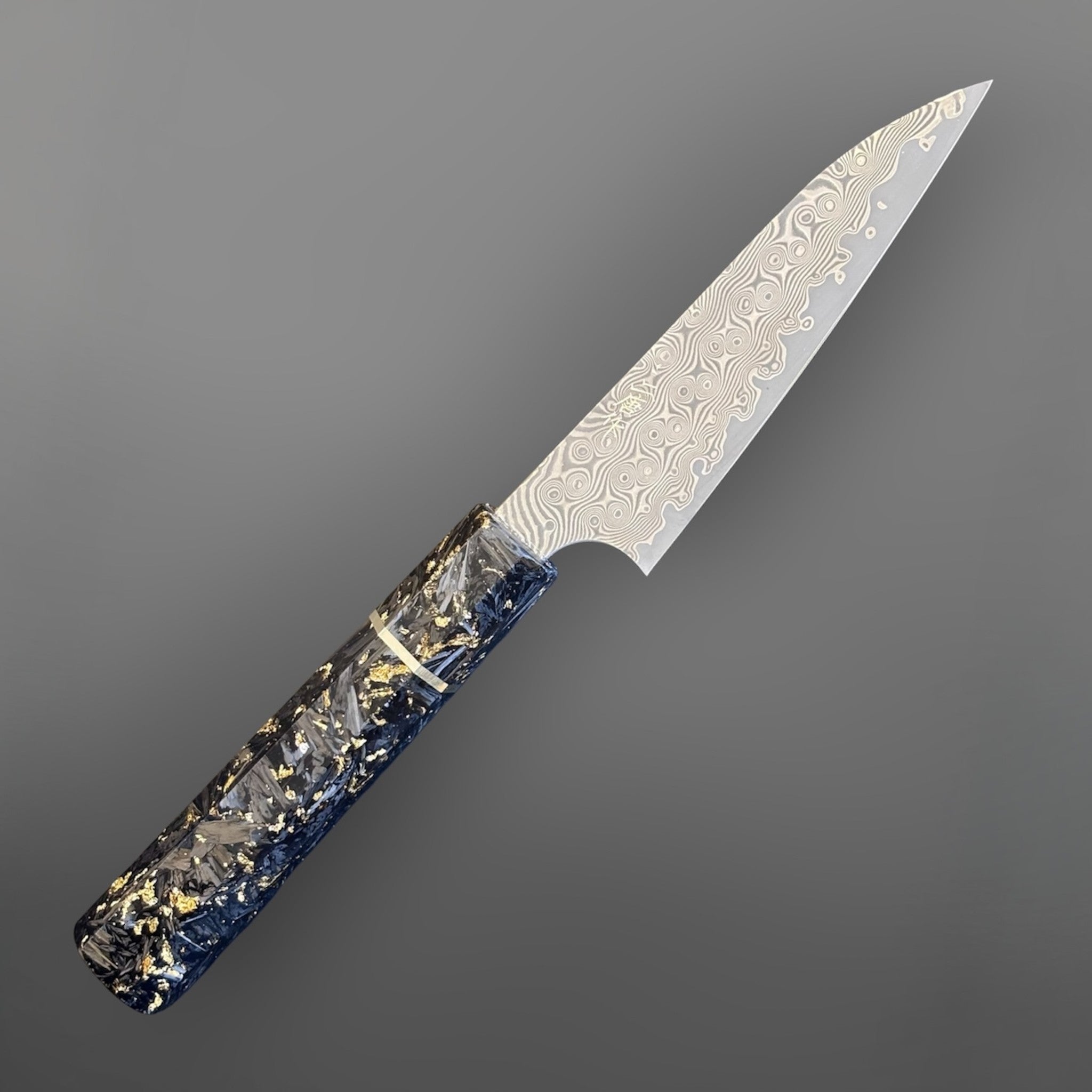 Nigara Anmon SG2 Petty 120 mm with carbon fiber and gold fleck handle, angled full-knife view showing the damascus pattern.