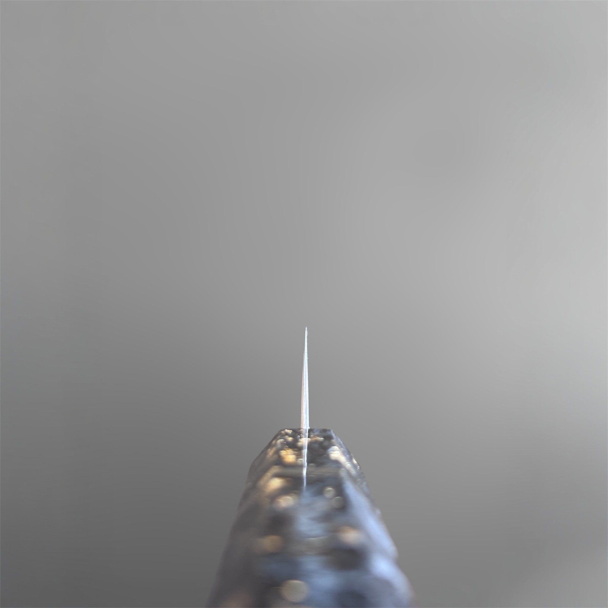 Nigara Anmon SG2 Petty 150 mm with carbon fiber and gold fleck handle, spine view showing the thin edge profile.