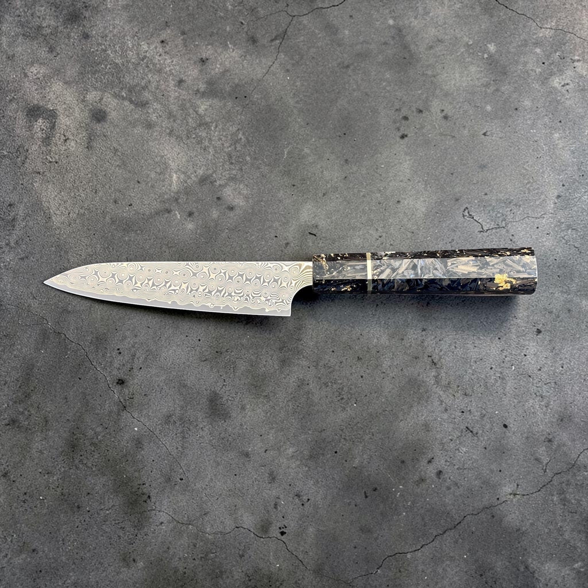 Nigara Anmon SG2 Petty 150 mm with carbon fiber and gold fleck handle, reverse horizontal full-profile product photo.