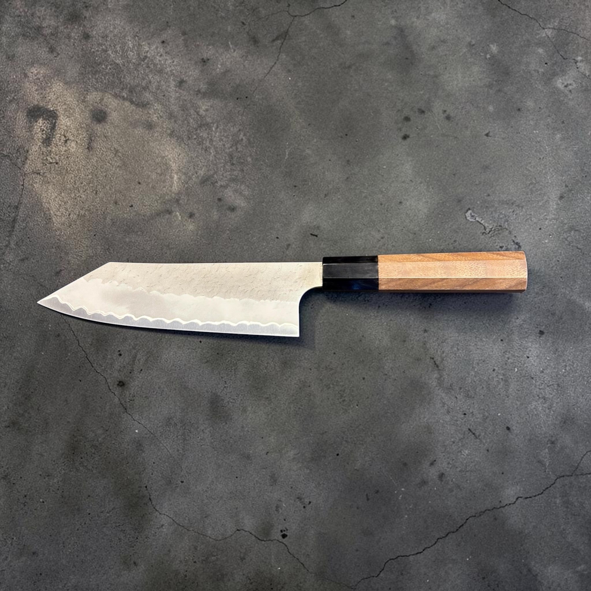 Nigara Aogami Super Steel Tsuchime Bunka 180 mm with walnut and horn handle, full profile view with blade facing left.