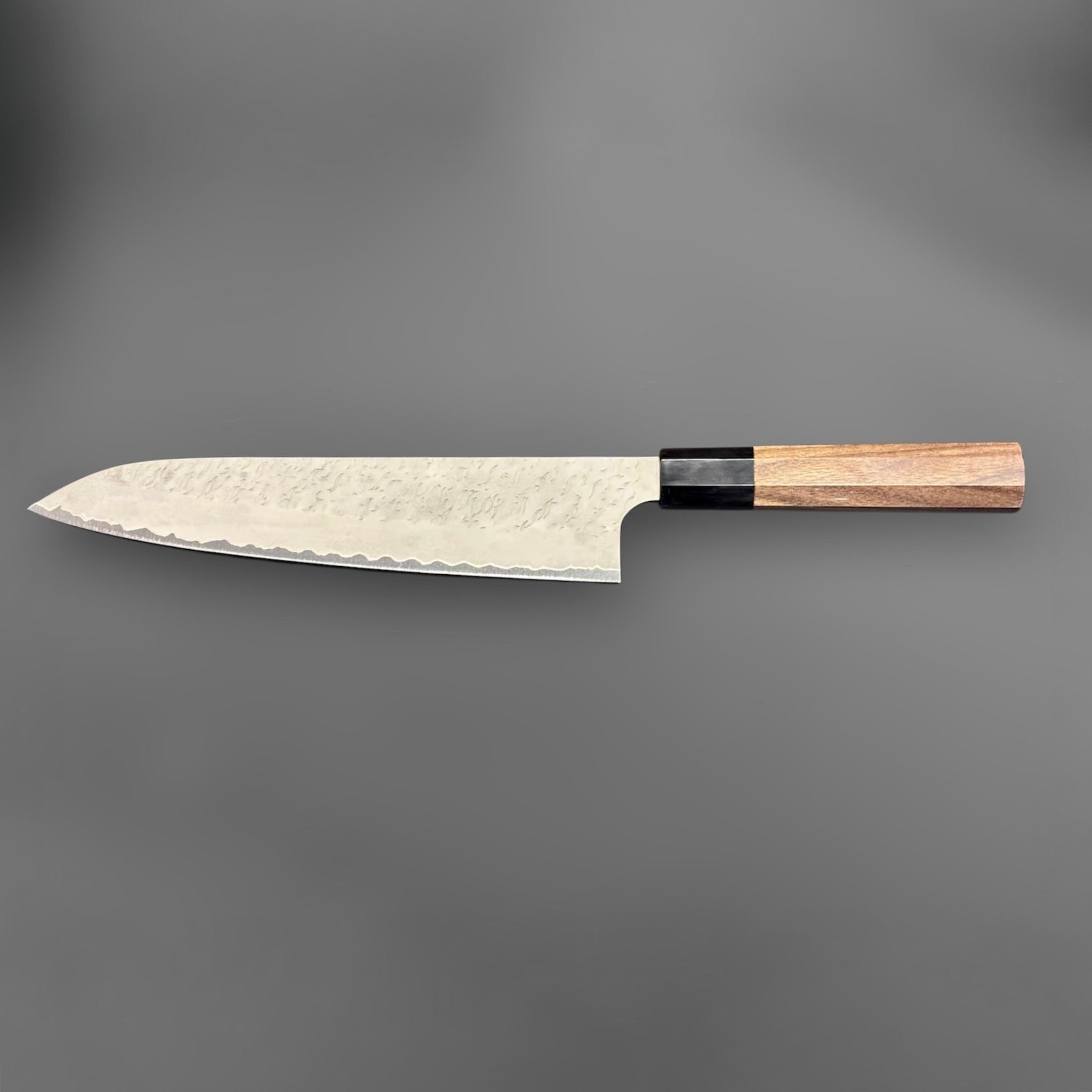 Nigara Aogami Super Steel Tsuchime Gyuto 240 mm with walnut and black horn handle, full profile view with blade facing left.