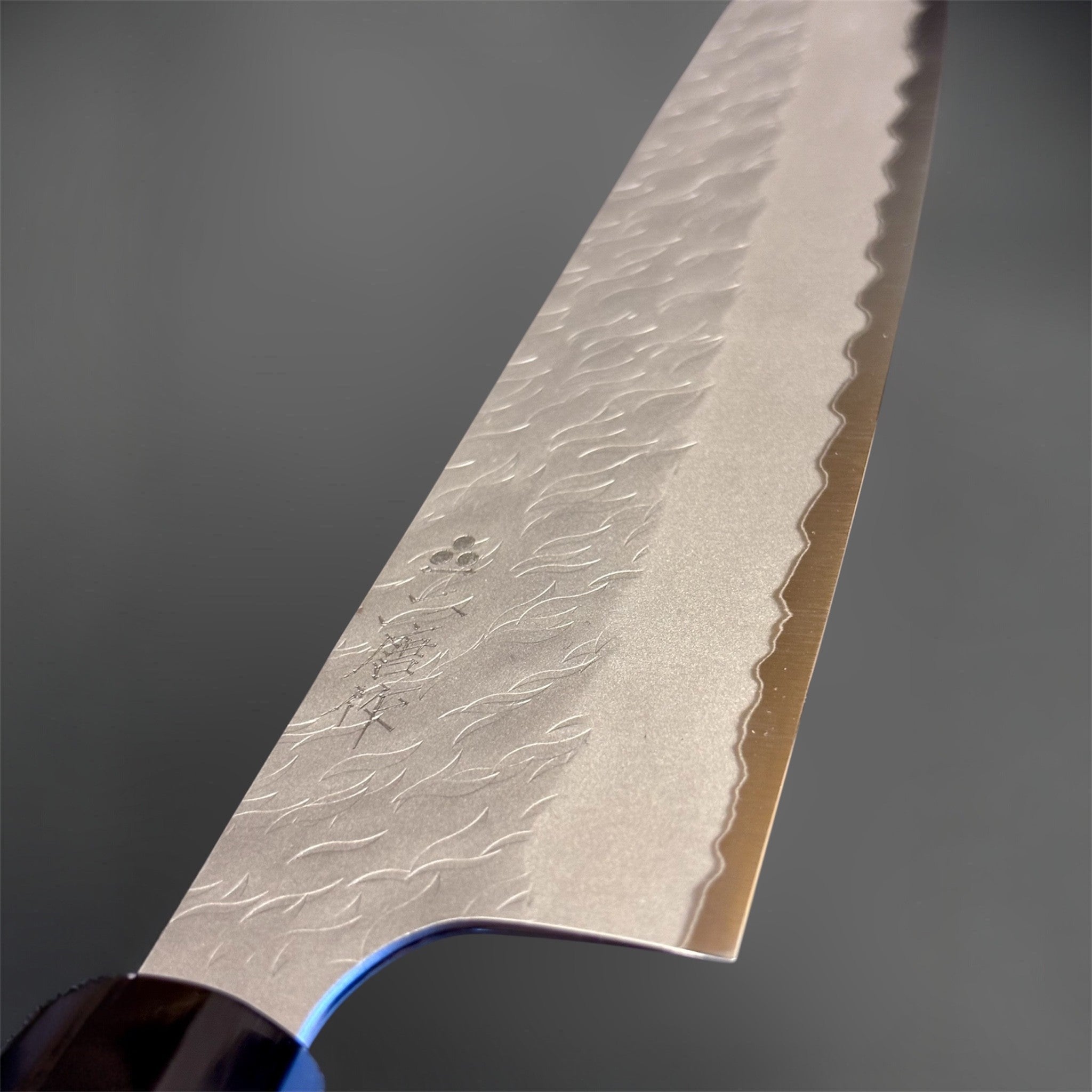 Nigara Aogami Super Steel Tsuchime Gyuto 240 mm with walnut and black horn handle, close-up of tsuchime texture and engraved blade details.