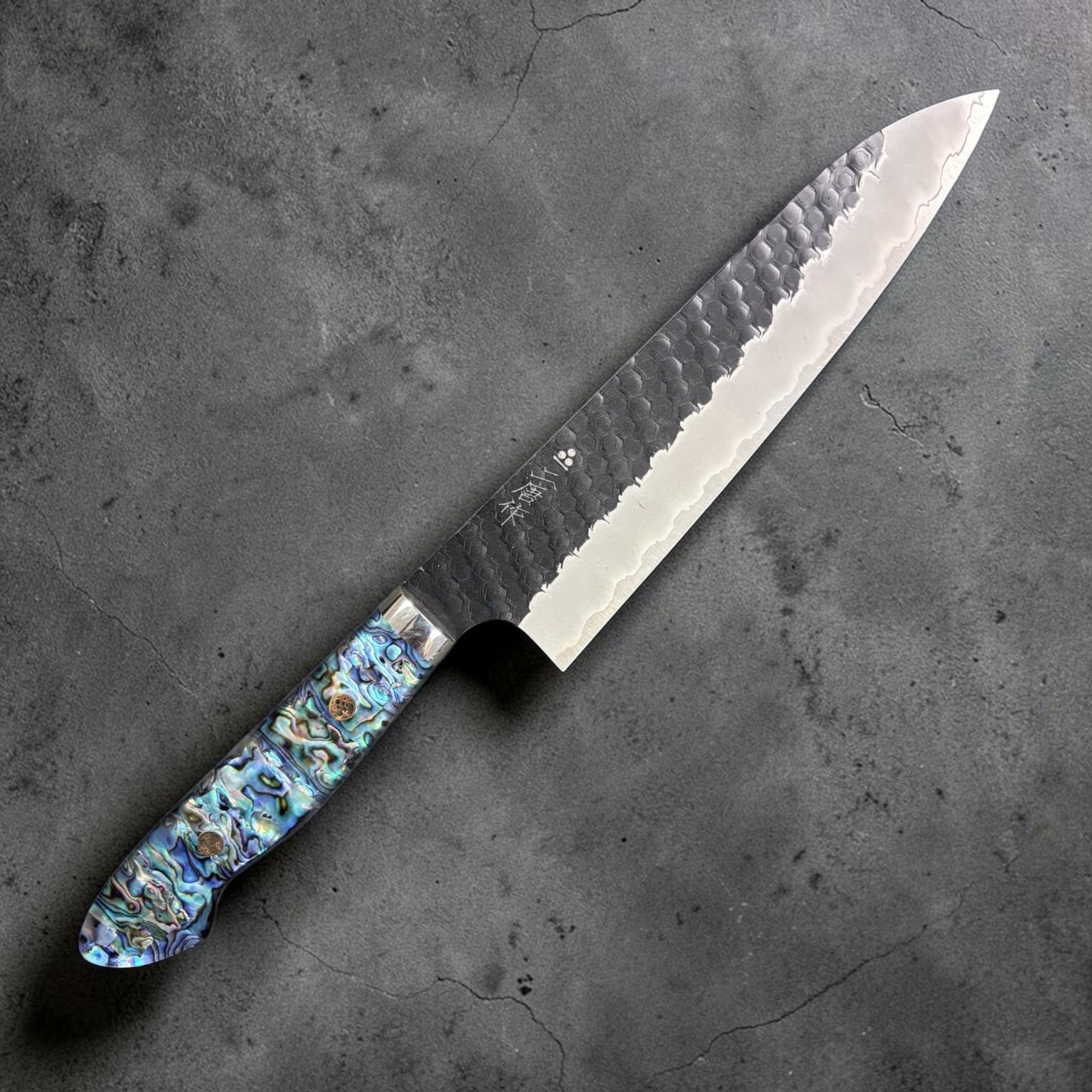 Nigara SG2 Kurouchi Tsuchime Gyuto 210 mm, right side profile showing hammered finish and abalone Western handle.
