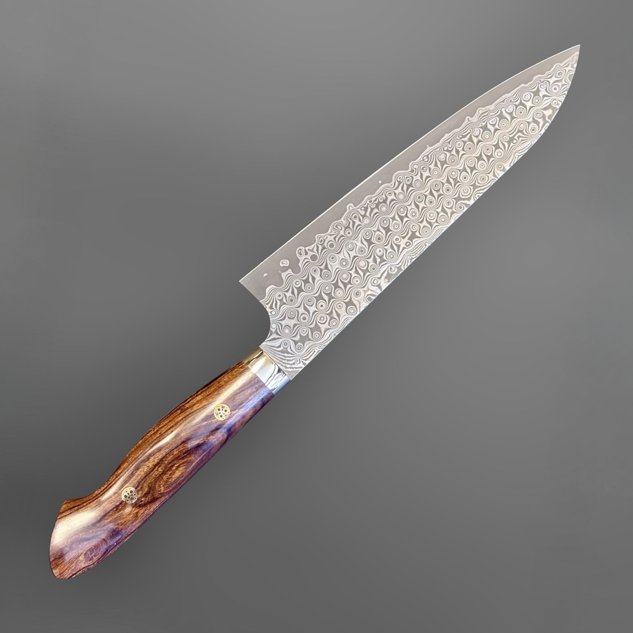 Nigara Hamono Anmon SG2 210 mm Gyuto with ironwood western handle, angled full knife view showing patterned blade and ironwood handle.