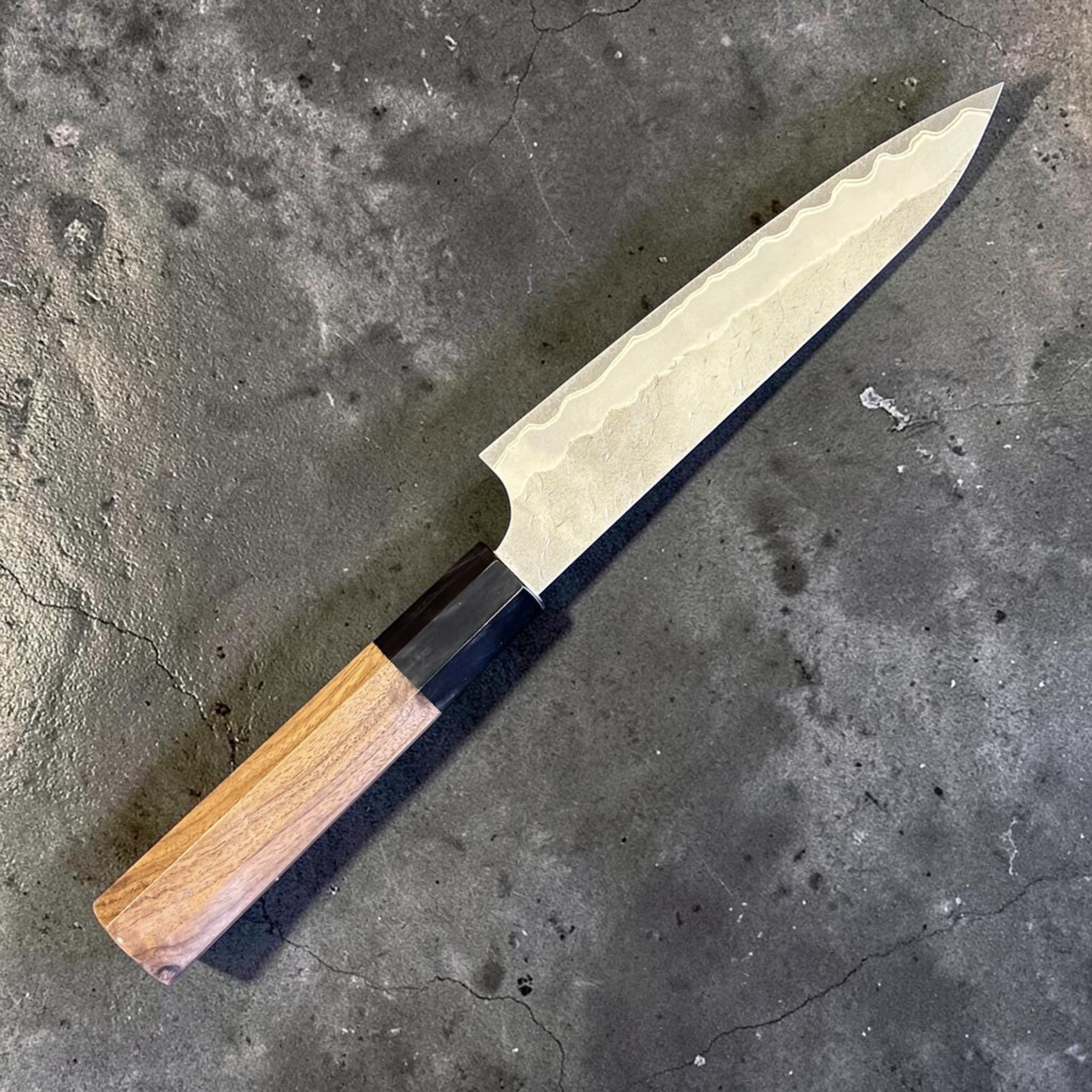 Nigara Hamono Aogami Super Tsuchime Petty 150 mm with walnut horn handle, reverse angled full knife view.
