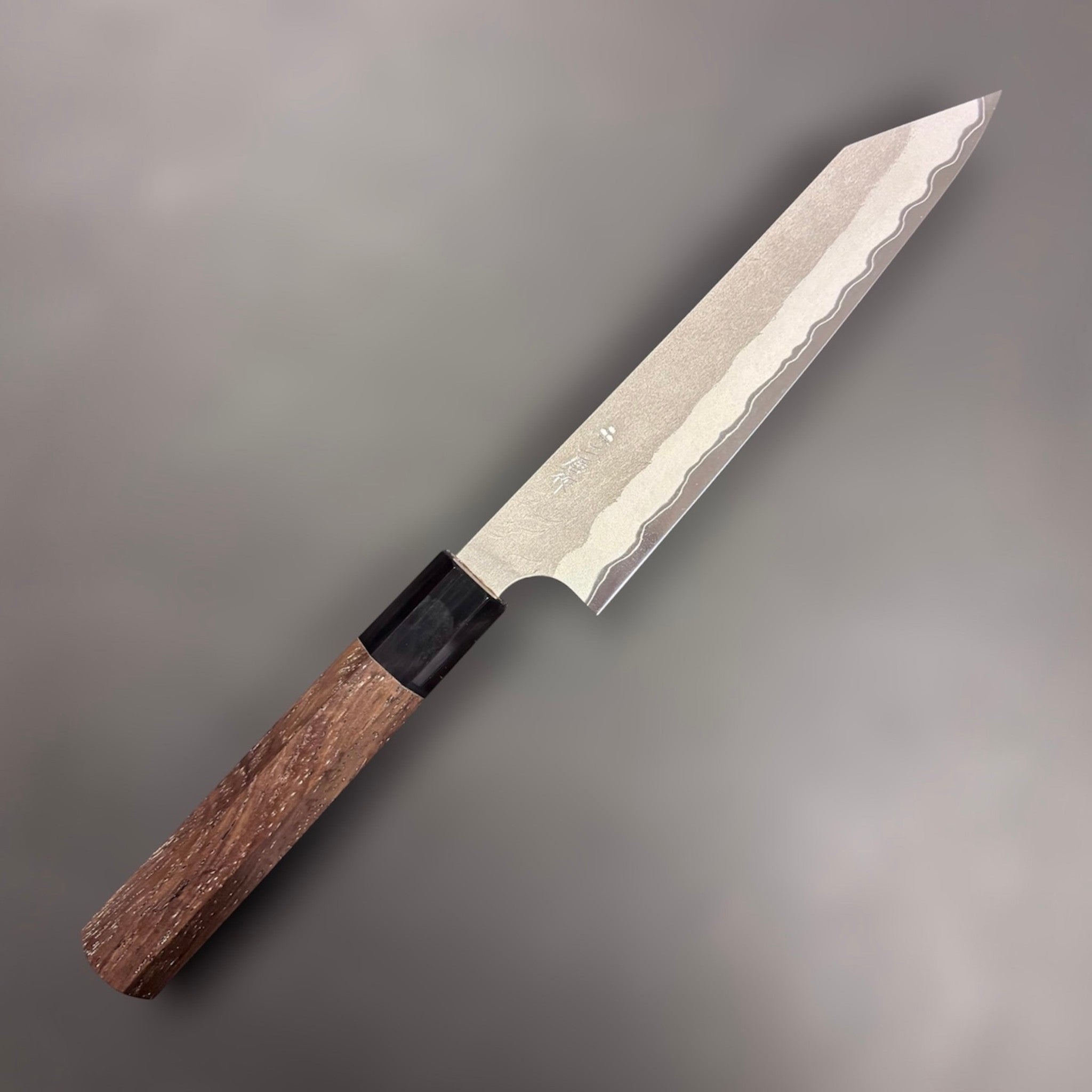 Nigara Hamono Aogami Super Tsuchime Kiritsuke Petty 150 mm with walnut handle, angled view of blade and handle on gray background.