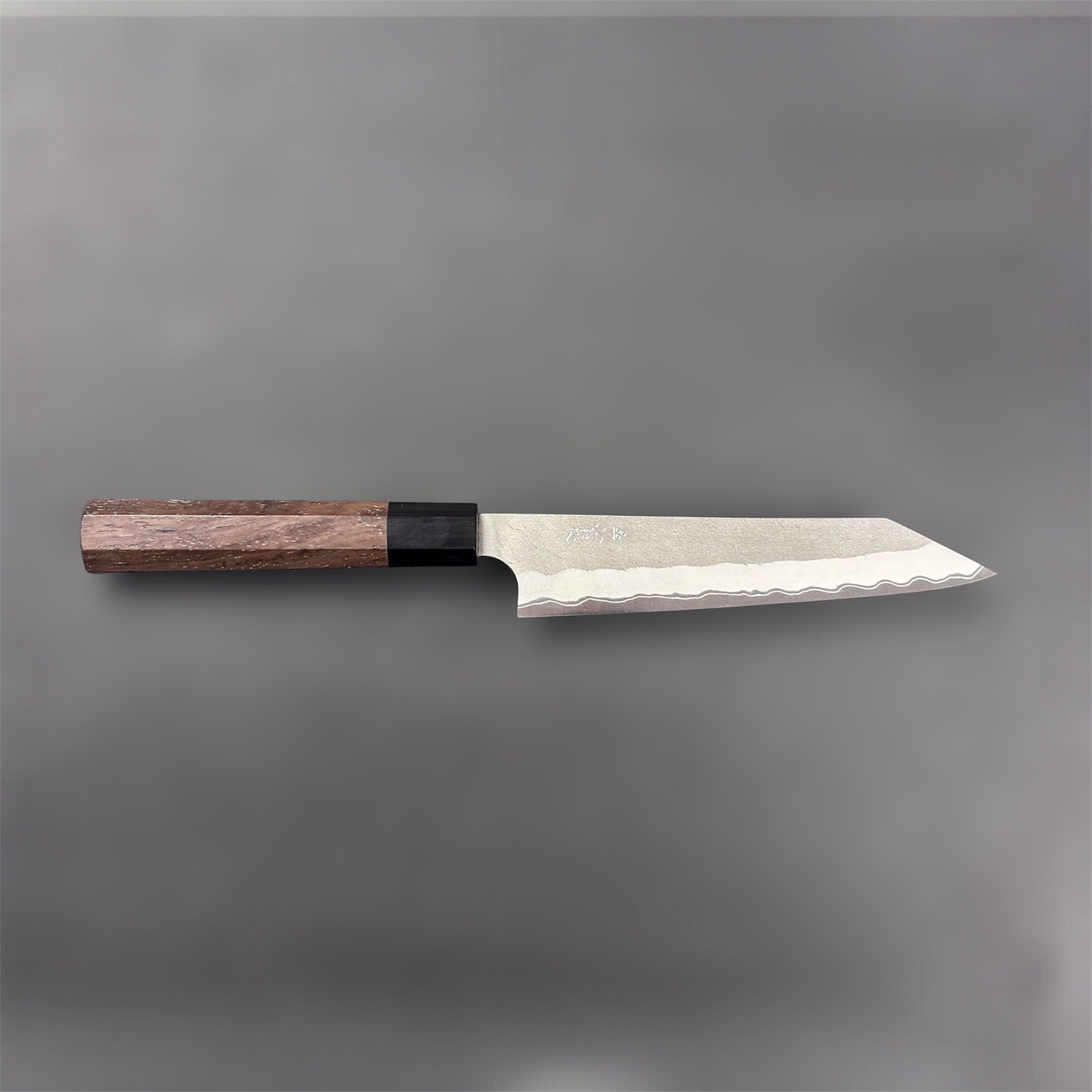 Nigara Hamono Aogami Super Tsuchime Kiritsuke Petty 150 mm with walnut handle, side profile, full knife horizontal on gray background.