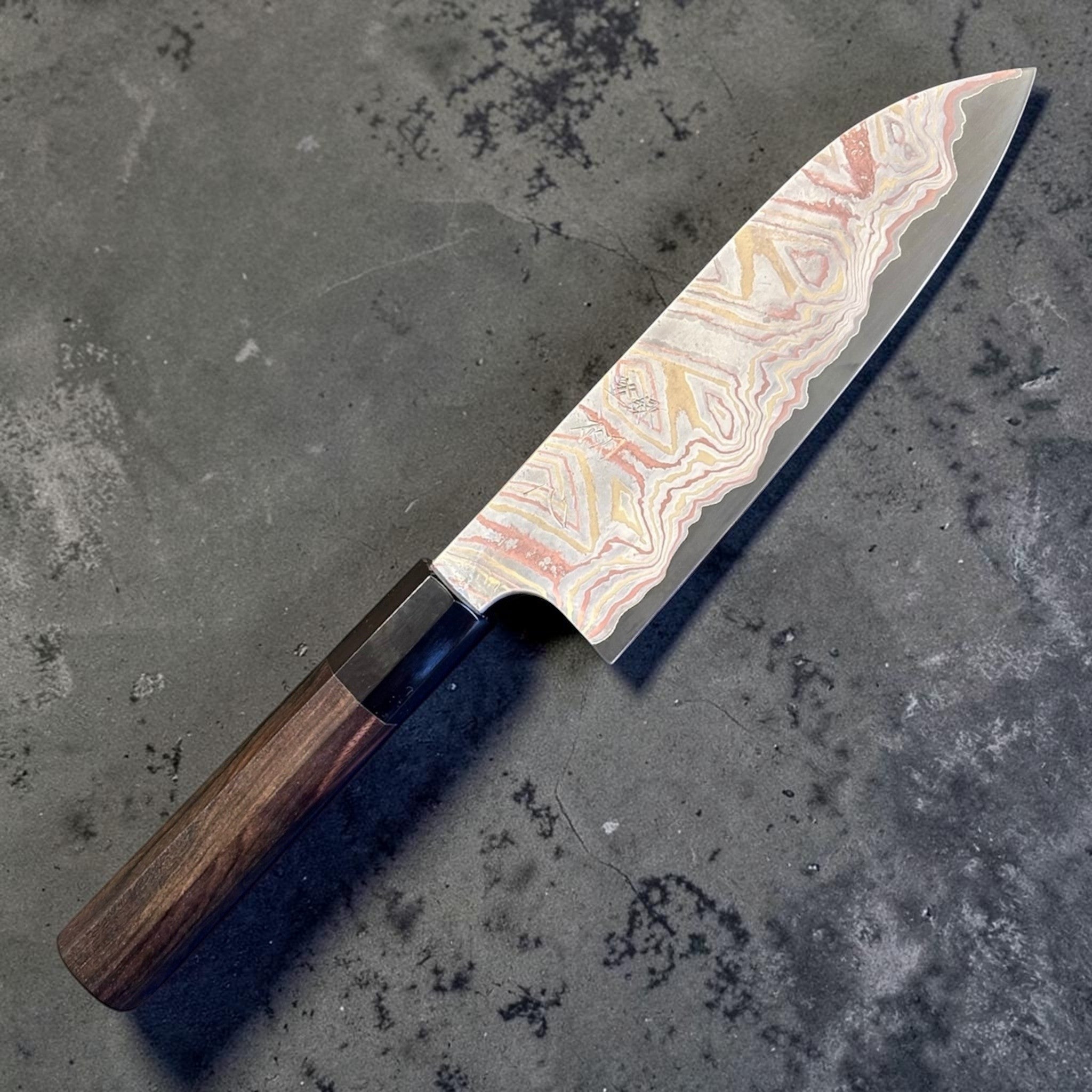 Nigara Irodori Blue #2 Rainbow Damascus Santoku 180 mm with ebony and horn handle, full profile view showing the flowing multicolor damascus pattern across the blade.