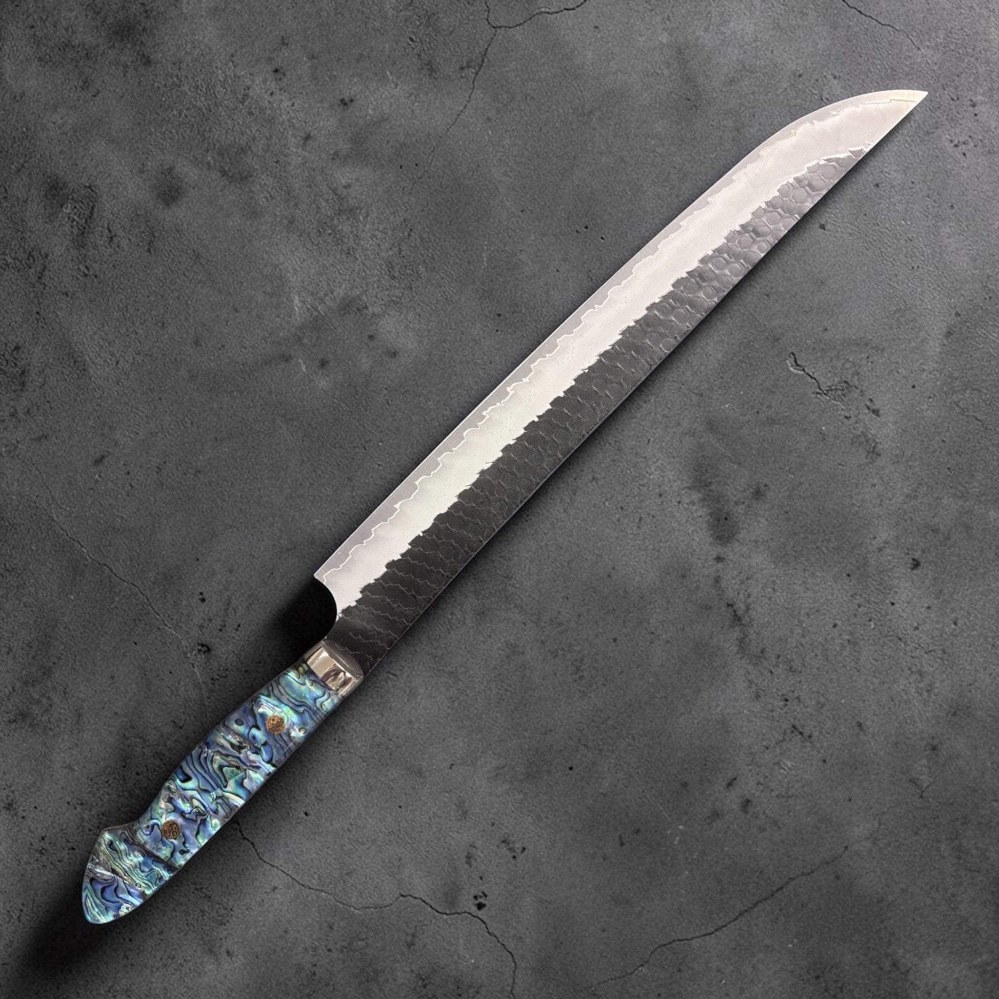 Nigara Hamono SG2 Kurouchi Tsuchime Sujihiki 300 mm with abalone western handle, left side profile.
