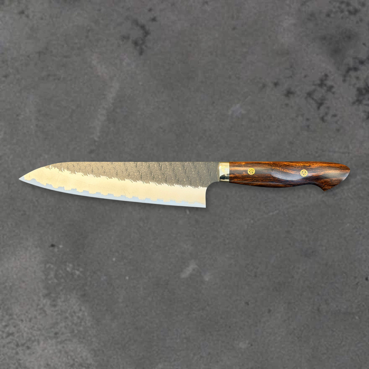Nigara SG2 Kurouchi Tsuchime 210mm gyuto with ironwood handle, shown in horizontal reverse profile with the full blade and handle visible.
