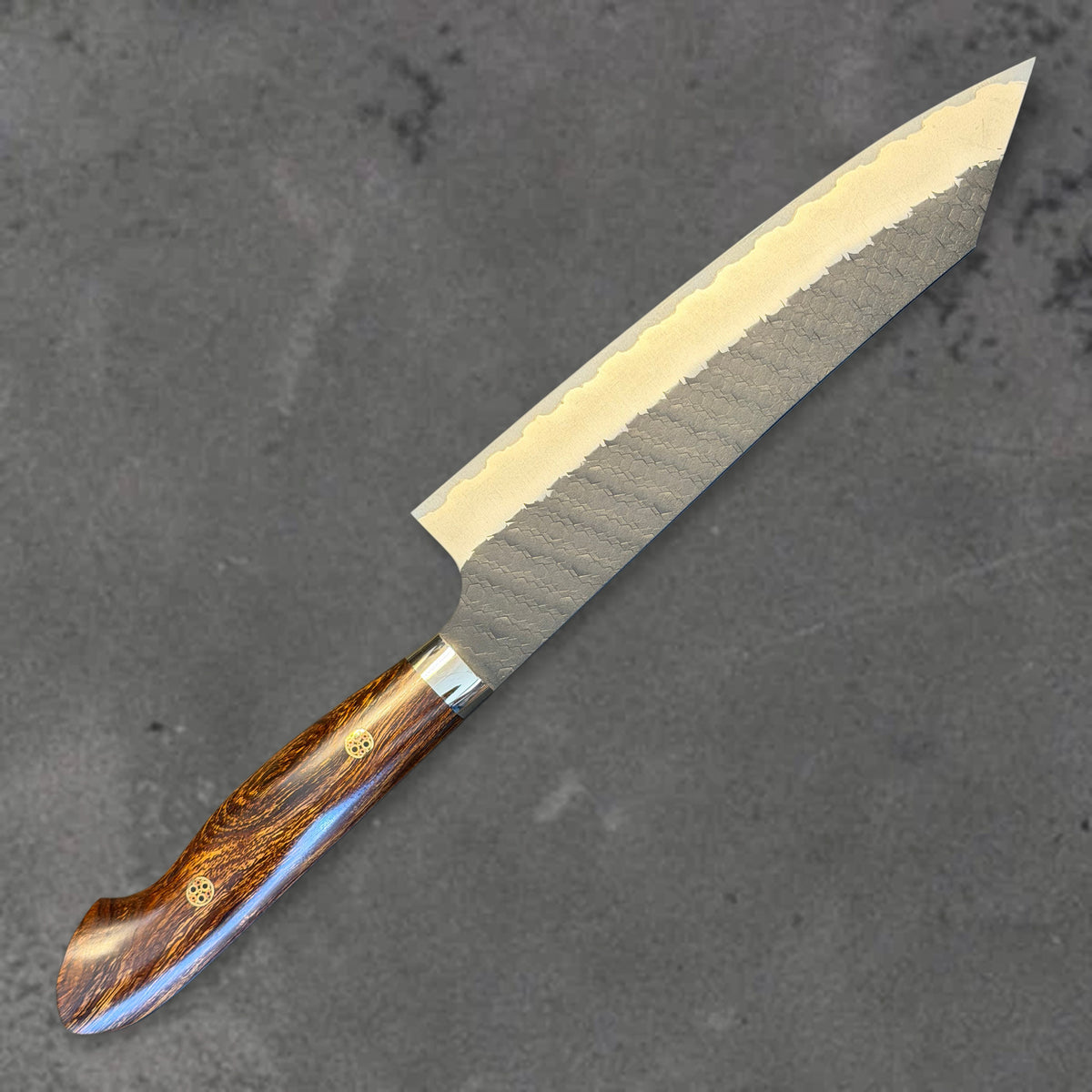 Angled reverse view of the Nigara SG2 Kurouchi Tsuchime 210mm kiritsuke with ironwood handle, showing the blade shape, finish, and handle.