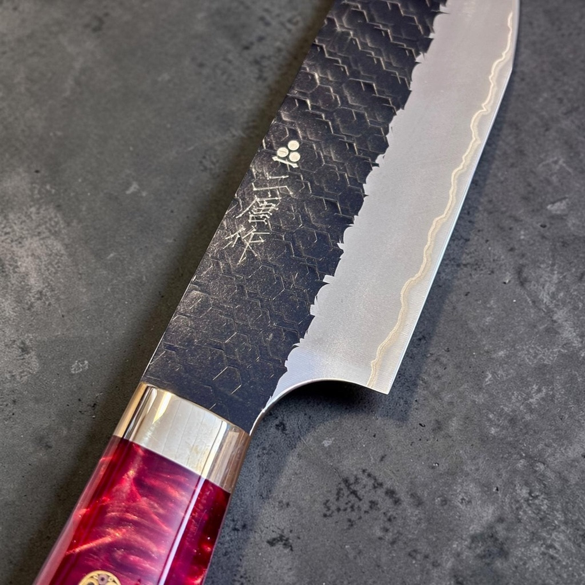 Nigara SG2 Kurouchi Tsuchime Sujihiki 255 mm with hybrid western handle, close-up of the hammered kurouchi finish and polished cutting edge.