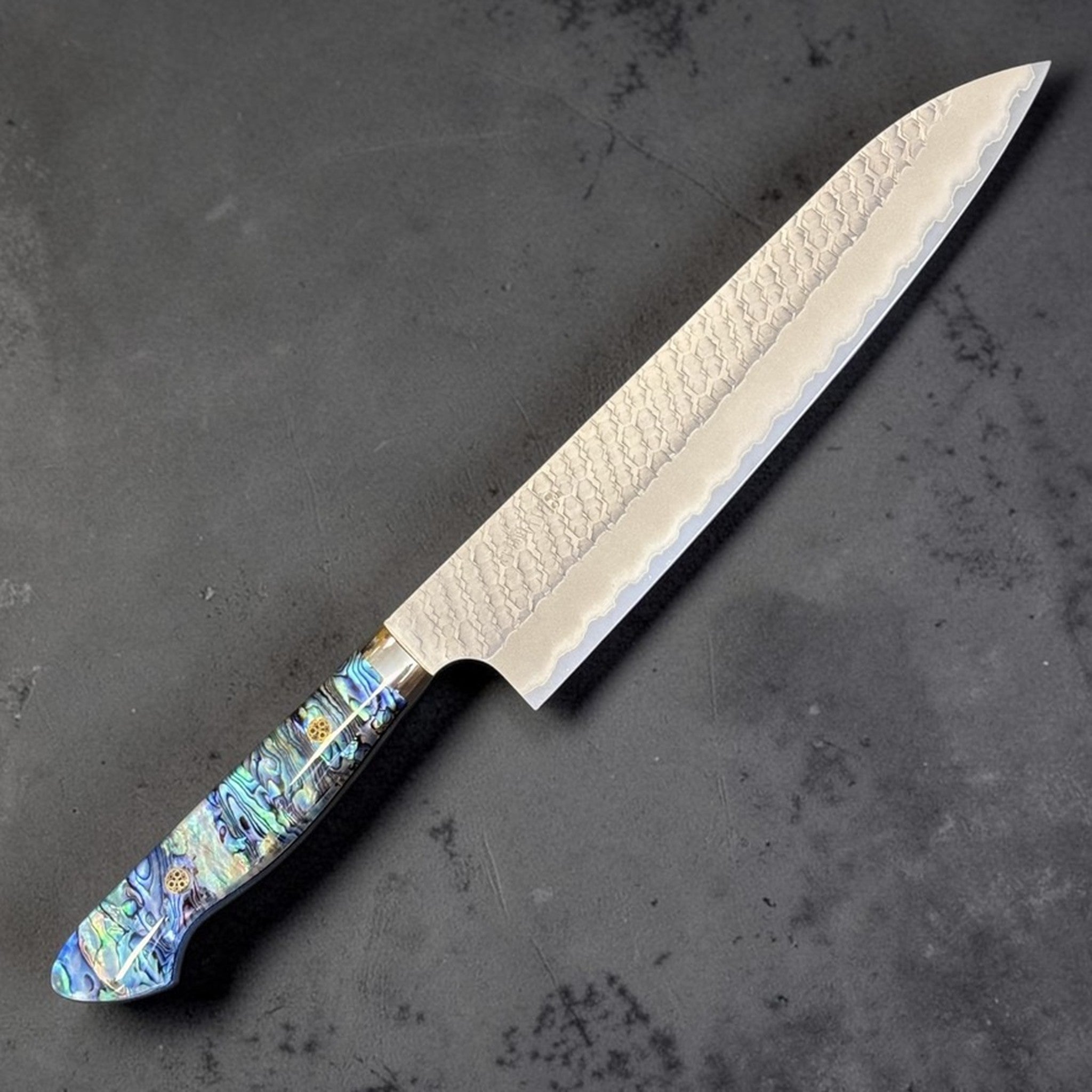 Nigara SG2 Tsuchime Gyuto 240 mm with abalone western handle, angled product view highlighting the tsuchime blade and colorful abalone handle.