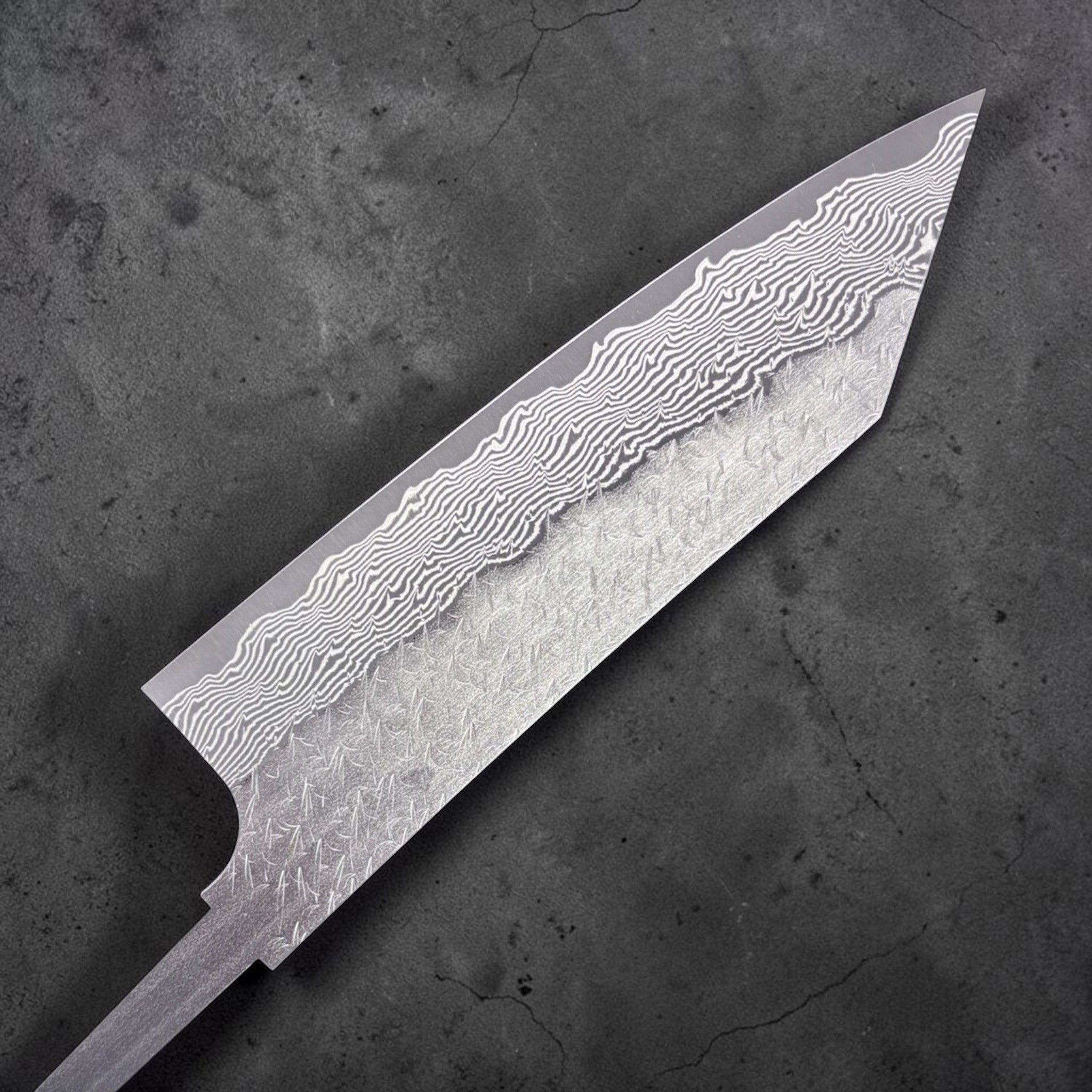 Nigara Strix Damascus Bunka 180 mm blade, angled macro view emphasizing the layered Strix Damascus and textured cladding.