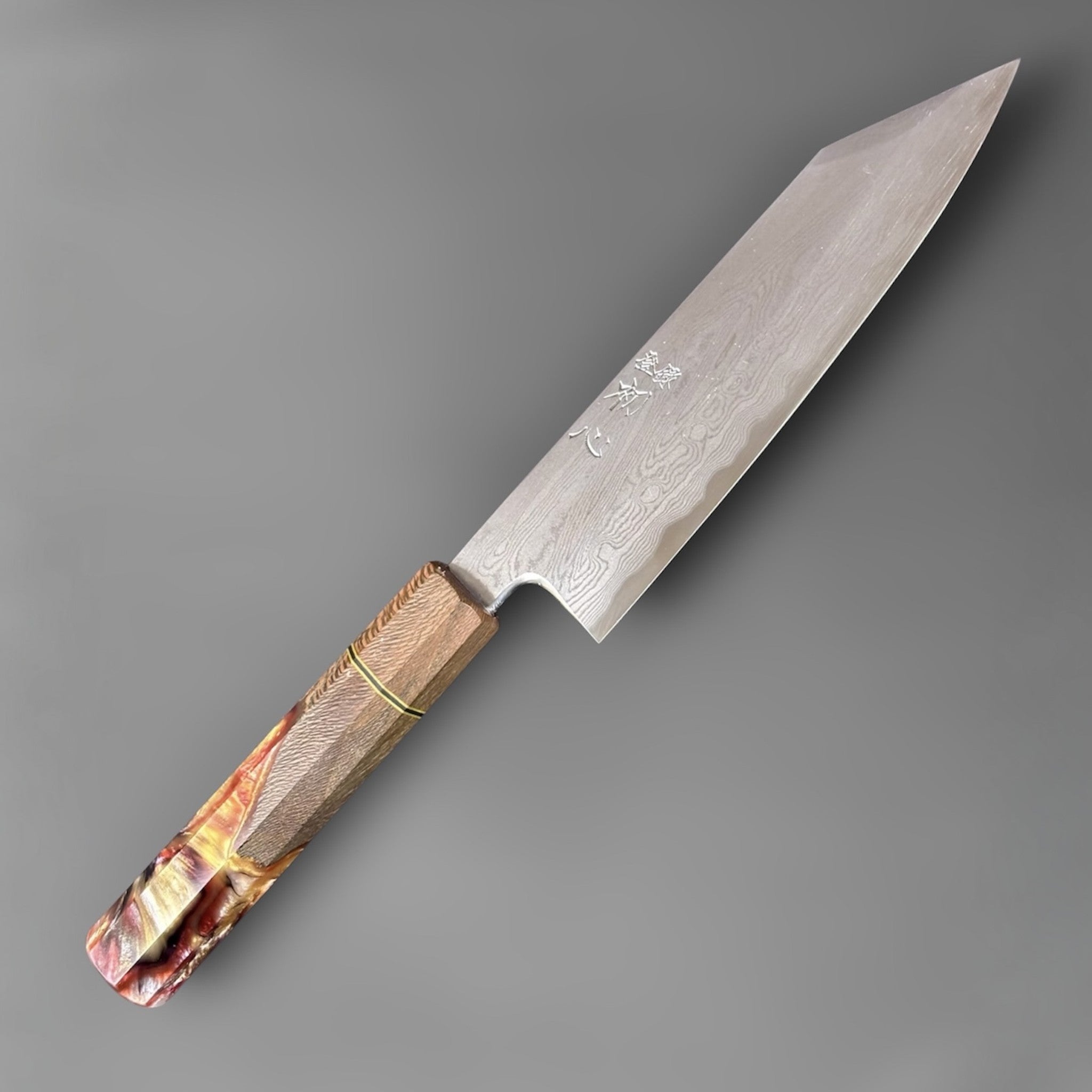 Satoshi Nakagawa Blue #1 Damascus Bunka 180 mm with Prisma Knife handle, angled full-knife view showing the k-tip profile and flowing Damascus blade pattern.