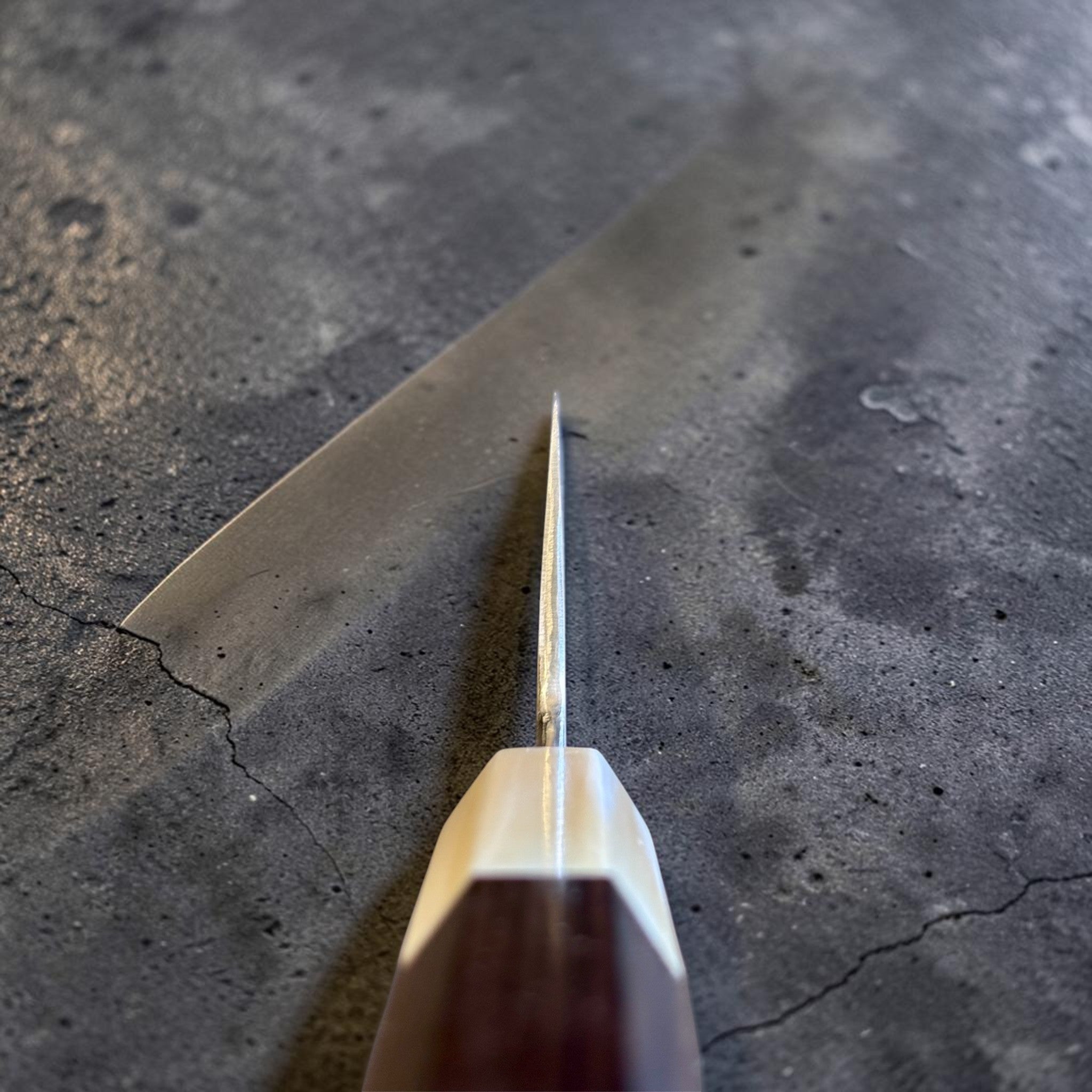 Satoshi Nakagawa Blue #1 Damascus Santoku with ebony and horn handle, choil view showing thin edge geometry and octagonal wa handle construction.