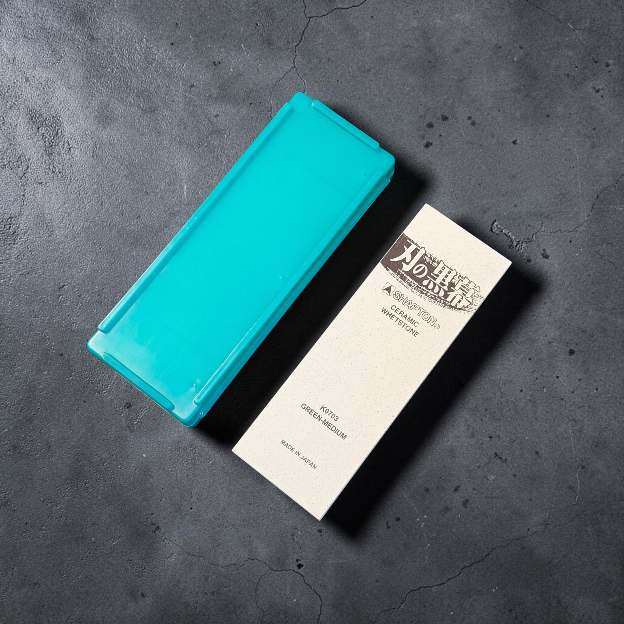 Shapton Kuromaku K0703 2000 grit whetstone beside its green storage case