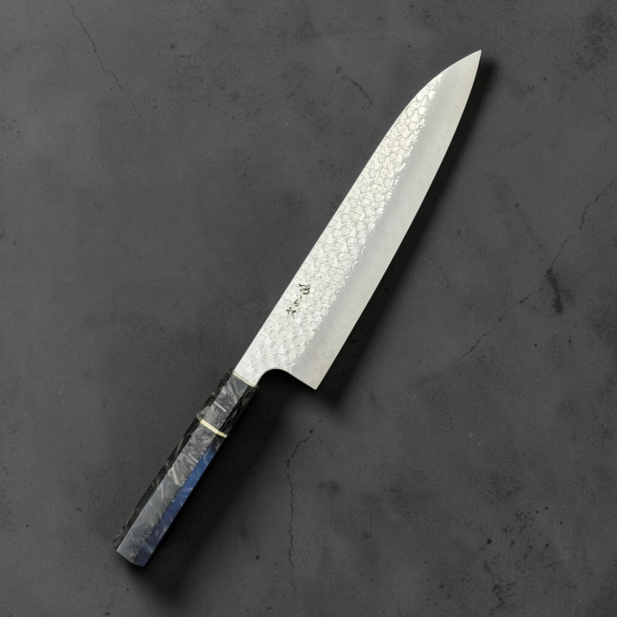 Shibata Arare SG2 gyuto 210mm with a black and grey carbon fiber octagonal handle, angled front view on a dark grey background.