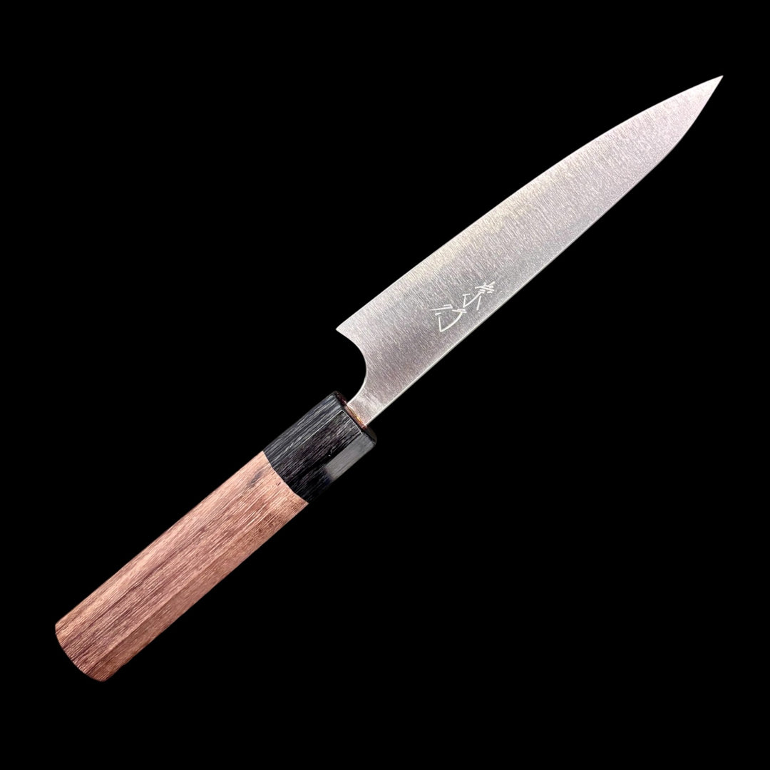 Shibata Koutetsu Aogami Super Petty 135 mm, left‑side profile with maker’s kanji on blade, walnut/ebony wa handle against black background.
