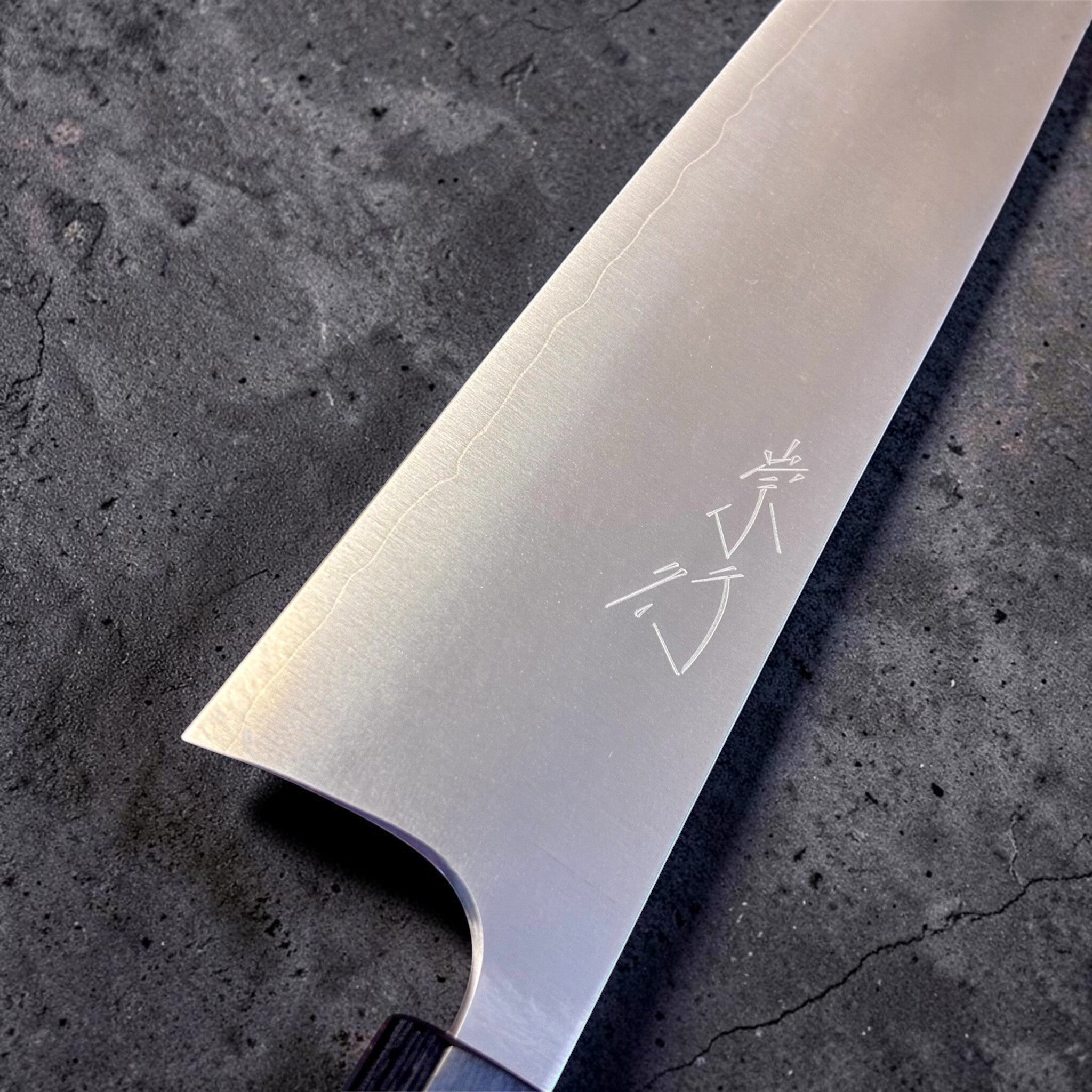 Shibata Koutetsu Chromax Gyuto 210 mm, close-up of blade face with kanji and visible cladding line.