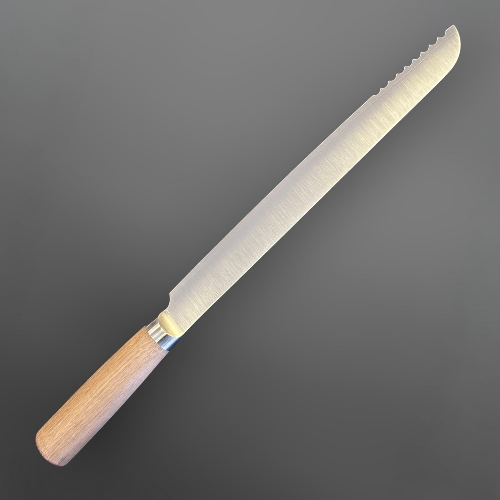Tadafusa SLD Bread Knife with light wood handle, angled reverse view showing the long brushed blade and scalloped teeth near the tip.