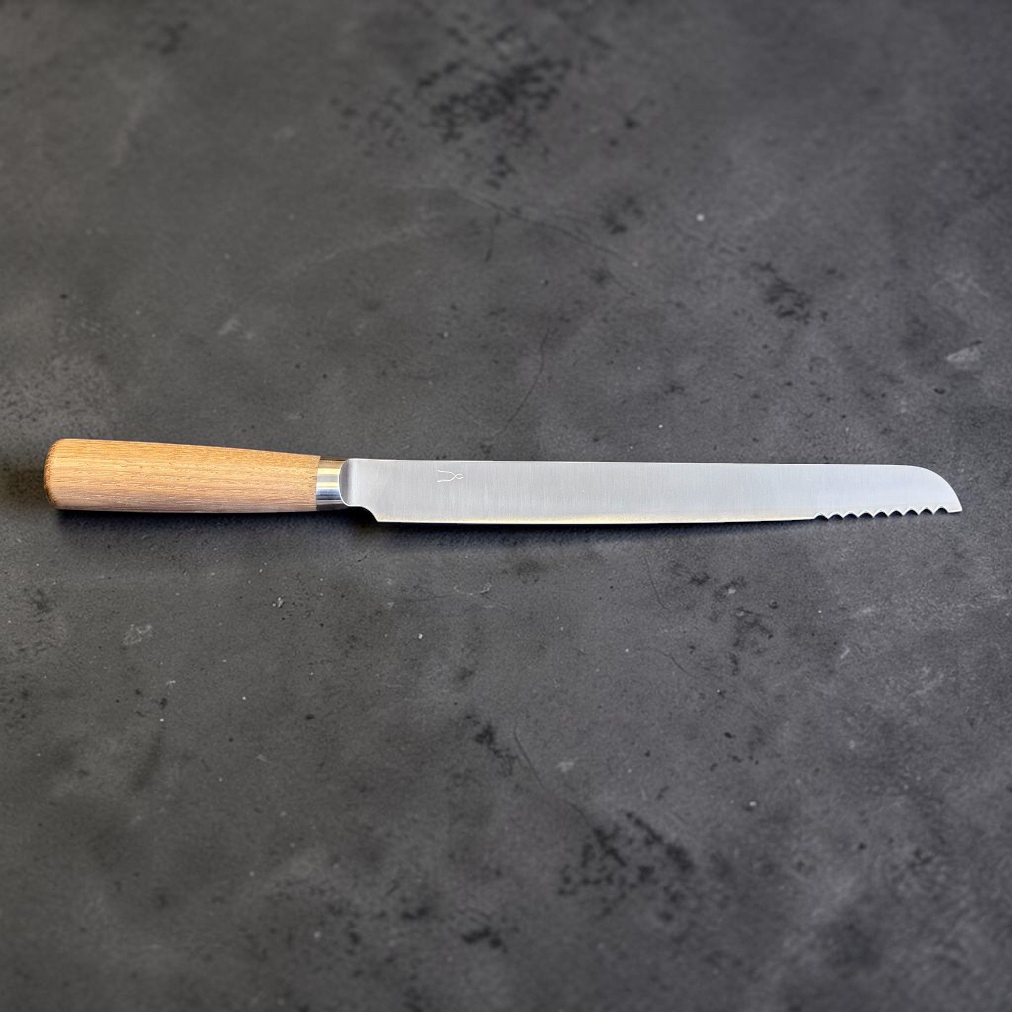 Tadafusa SLD Bread Knife with light wood handle, full side profile showing the blade shape and partial serrations.