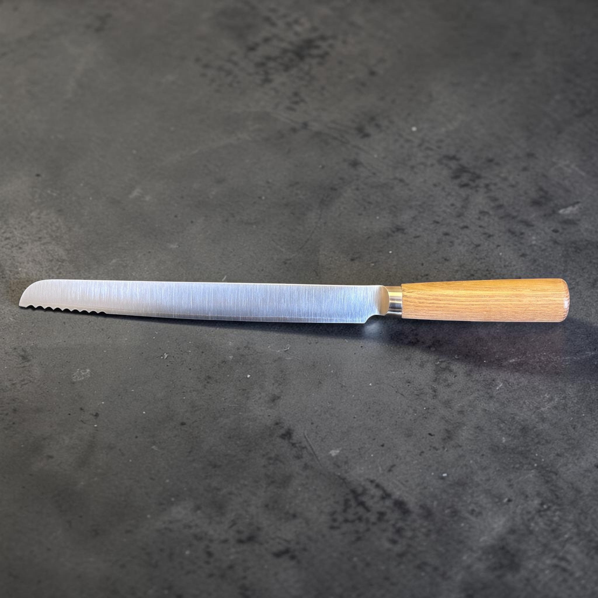 Tadafusa SLD Bread Knife with light wood handle, reverse side profile showing brushed SLD steel and handle fitment.