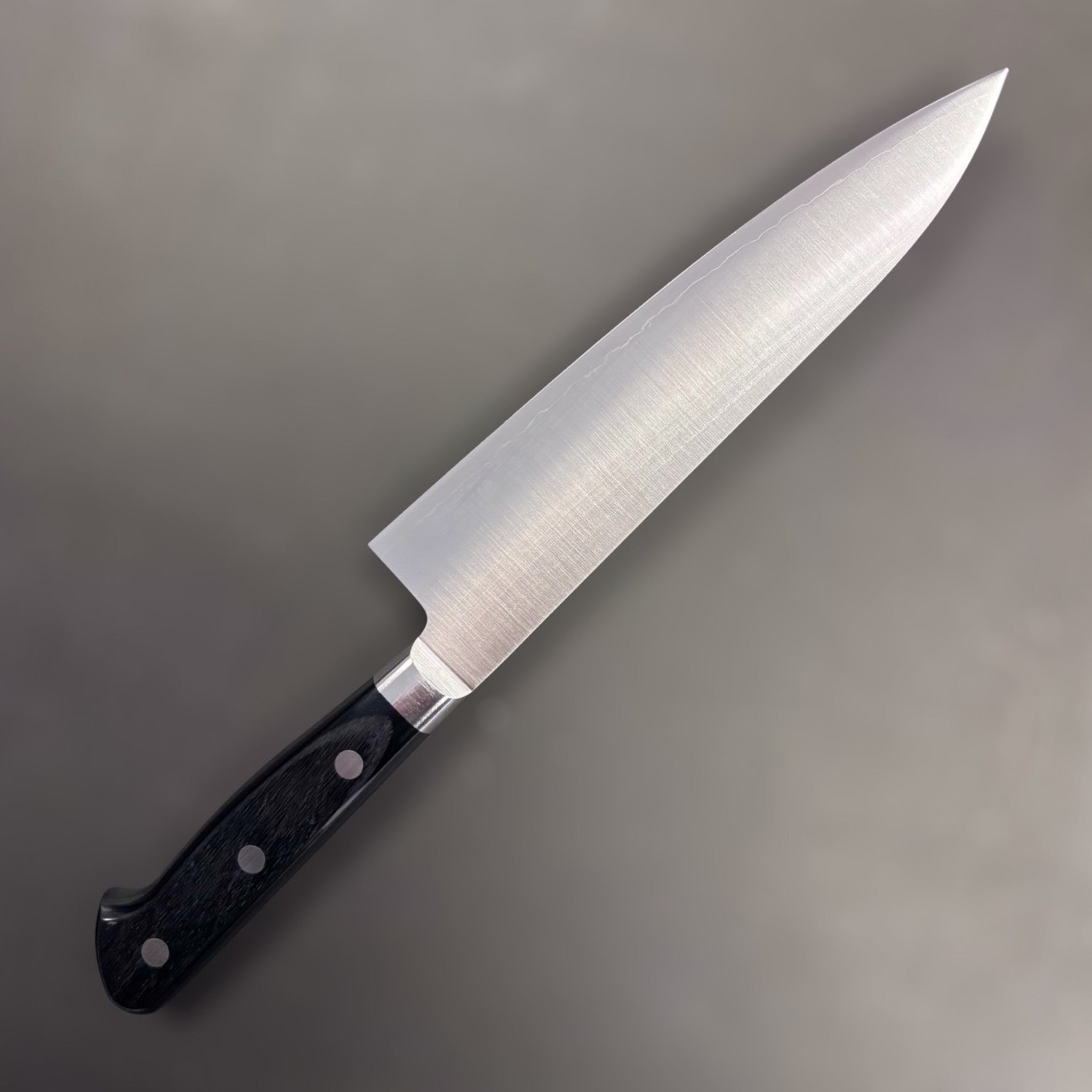 Takamura VG-10 Migaki Gyuto 180 mm, left side profile of polished blade with triple-rivet black Western handle.