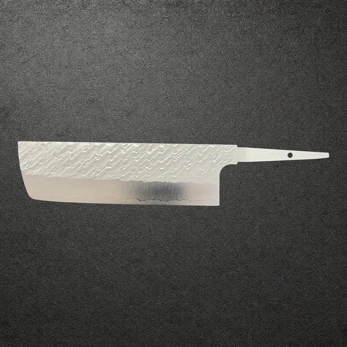 Full reverse profile of Takeshi Saji STRIX Tsuchime Nakiri blade only on charcoal concrete.
