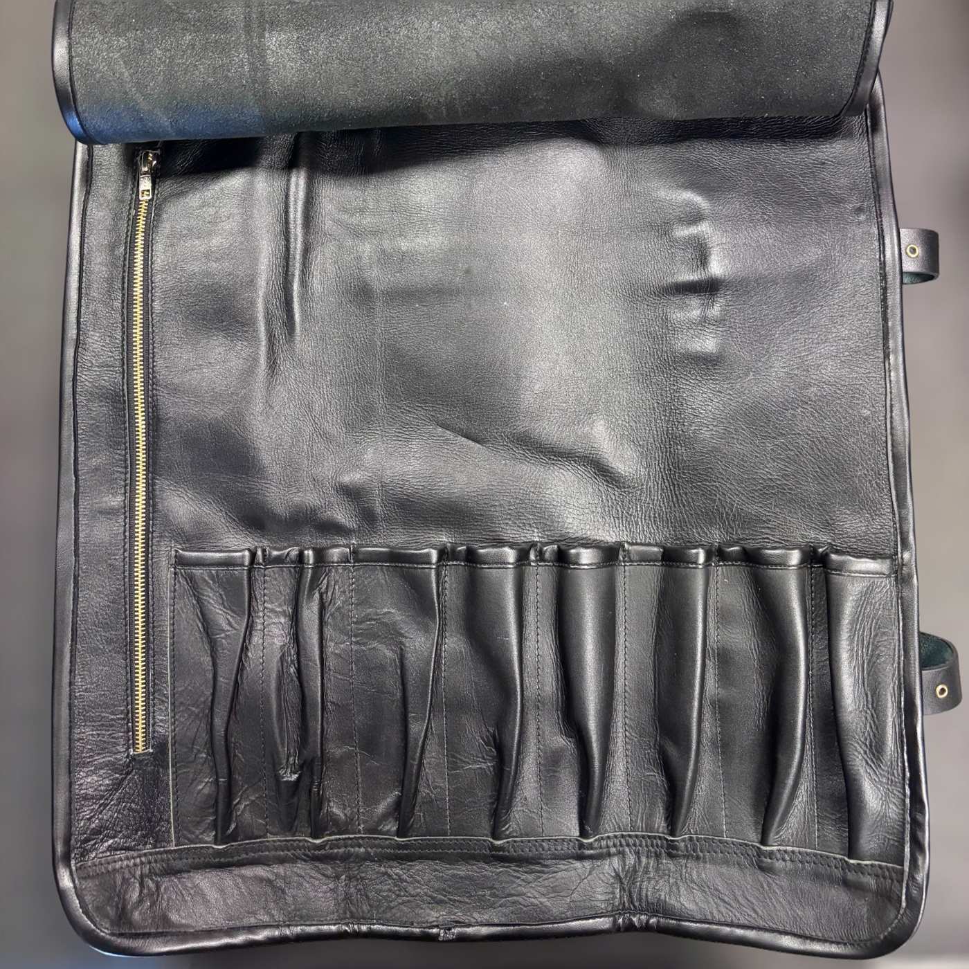 Tokushu Knife Premium Leather Knife Roll interior showing eight knife slots and left-side zip pocket in black leather