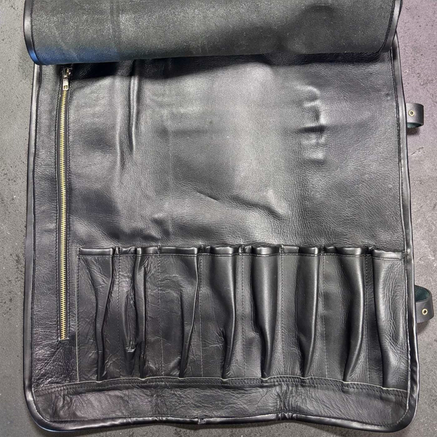 Tokushu Knife Premium Leather Knife Roll interior showing eight knife slots and left-side zip pocket in black leather