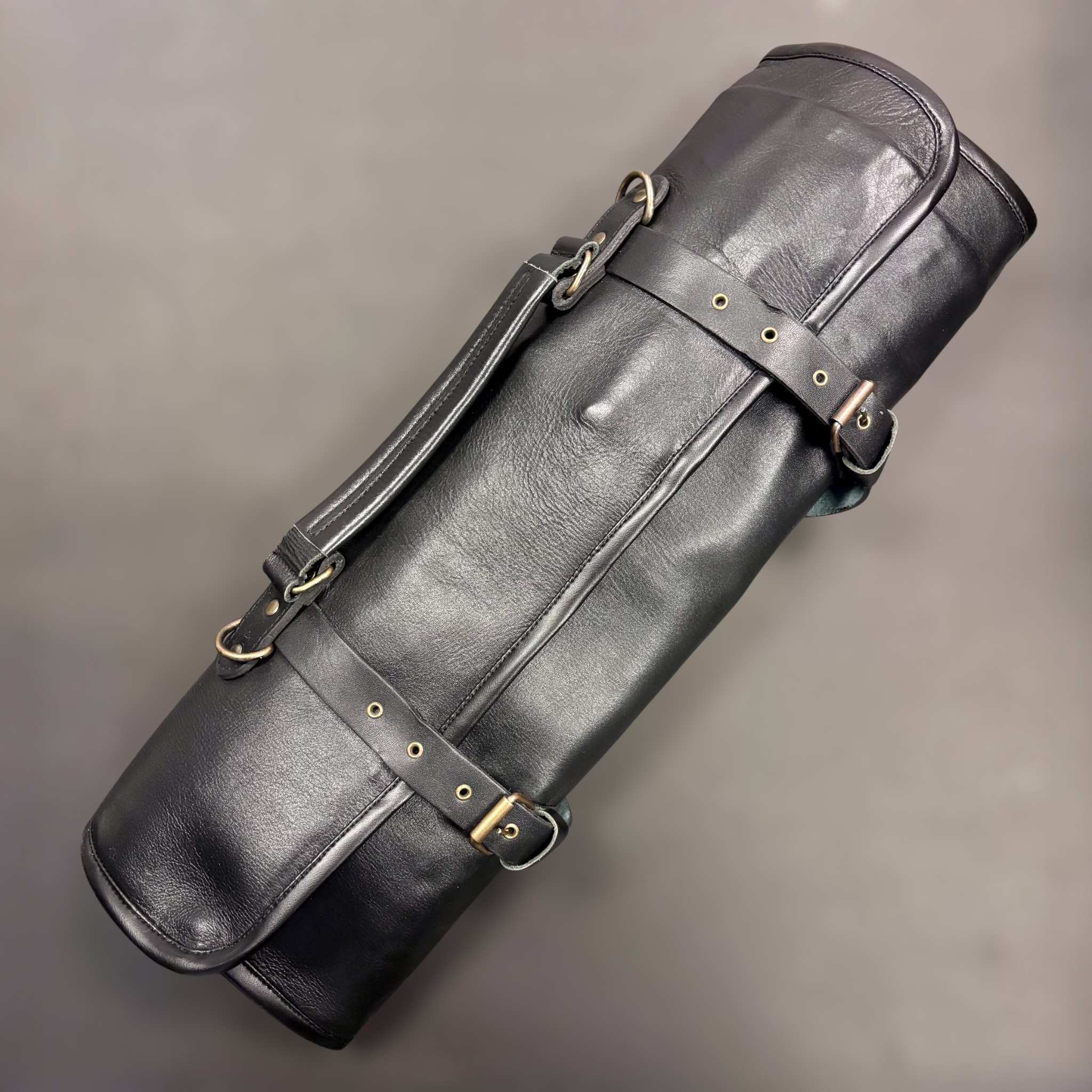 Tokushu Knife Premium Leather Knife Roll rolled up and secured with adjustable straps and shoulder handle
