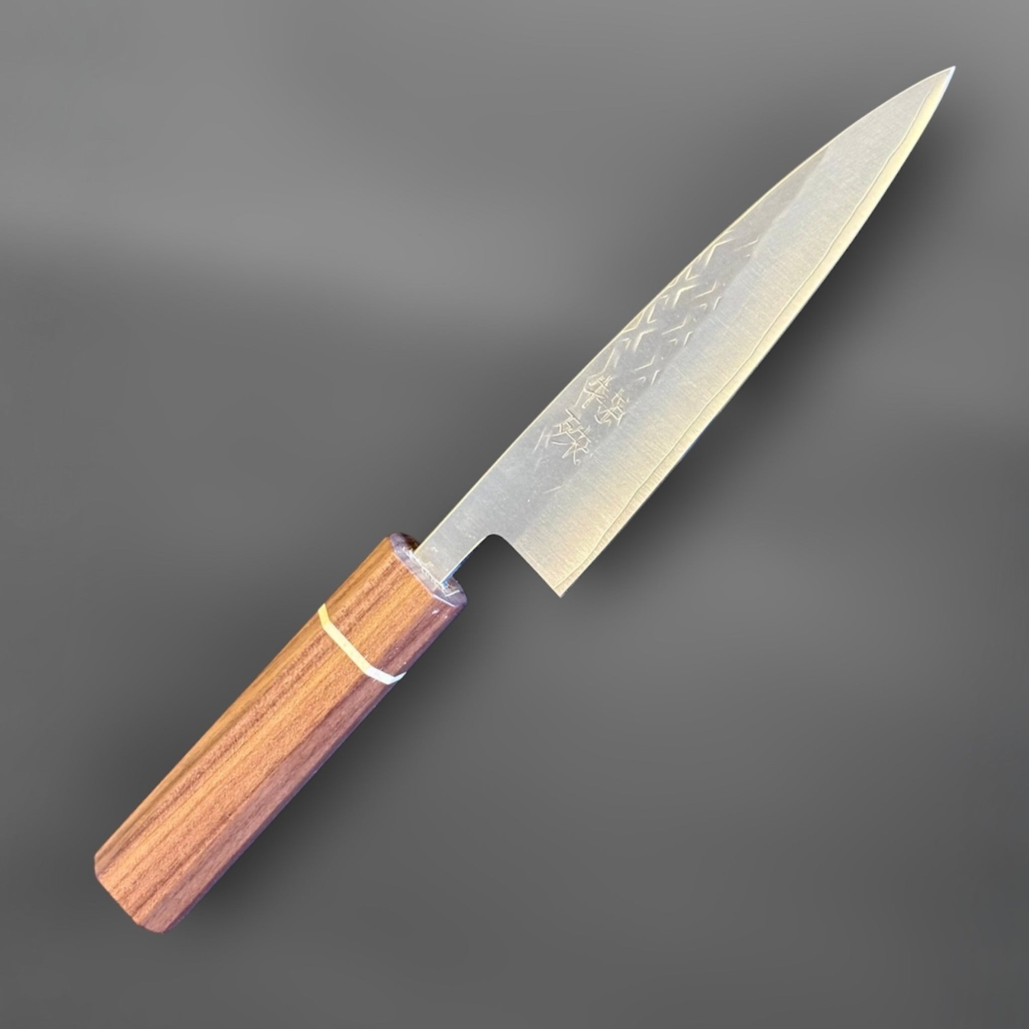 Tokushu Knife Tsuchime SLD 135 mm Petty, angled reverse-side view with engraved kanji, subtle tsuchime texture, and clean edge line.