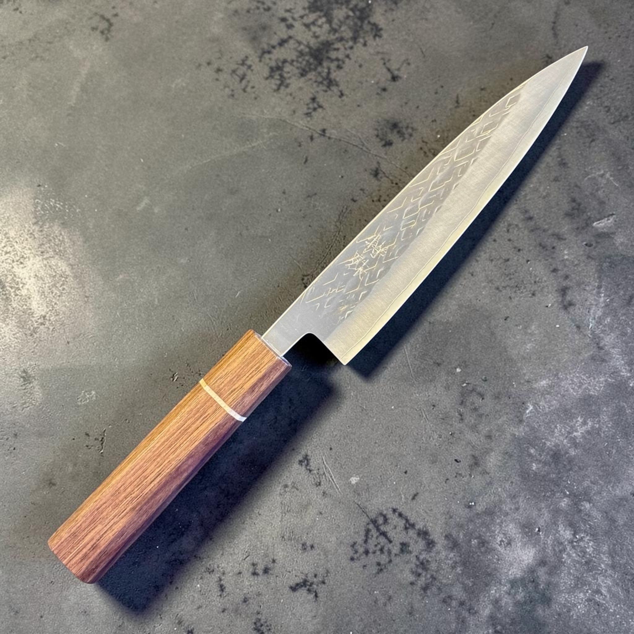 Tokushu Knife Tsuchime SLD 165 mm Hiraki Petty, angled front view highlighting the narrow pointed blade and octagonal wood wa handle.