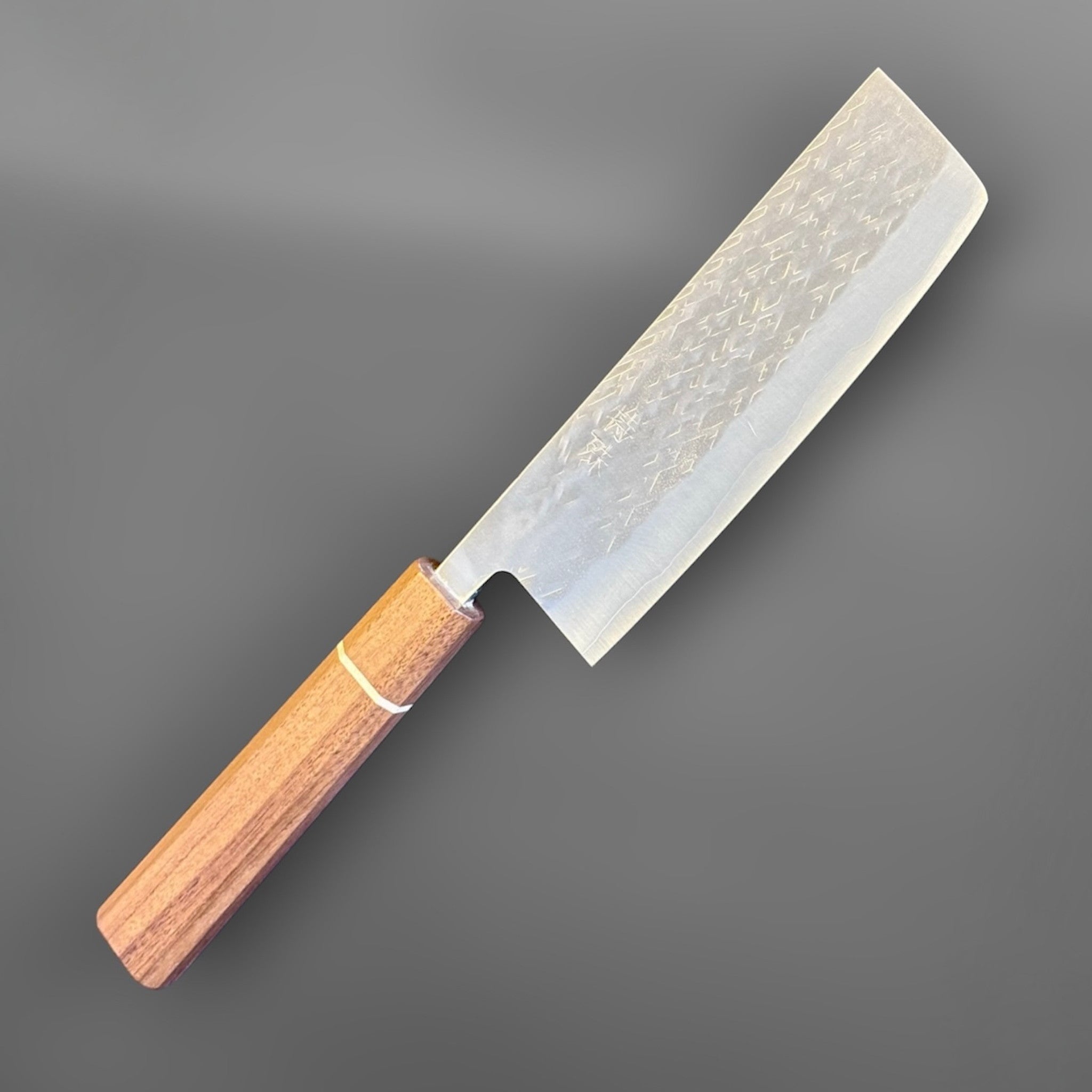 Tokushu Knife Tsuchime SLD Nakiri, angled front view highlighting the tall rectangular vegetable knife profile and wood wa handle.