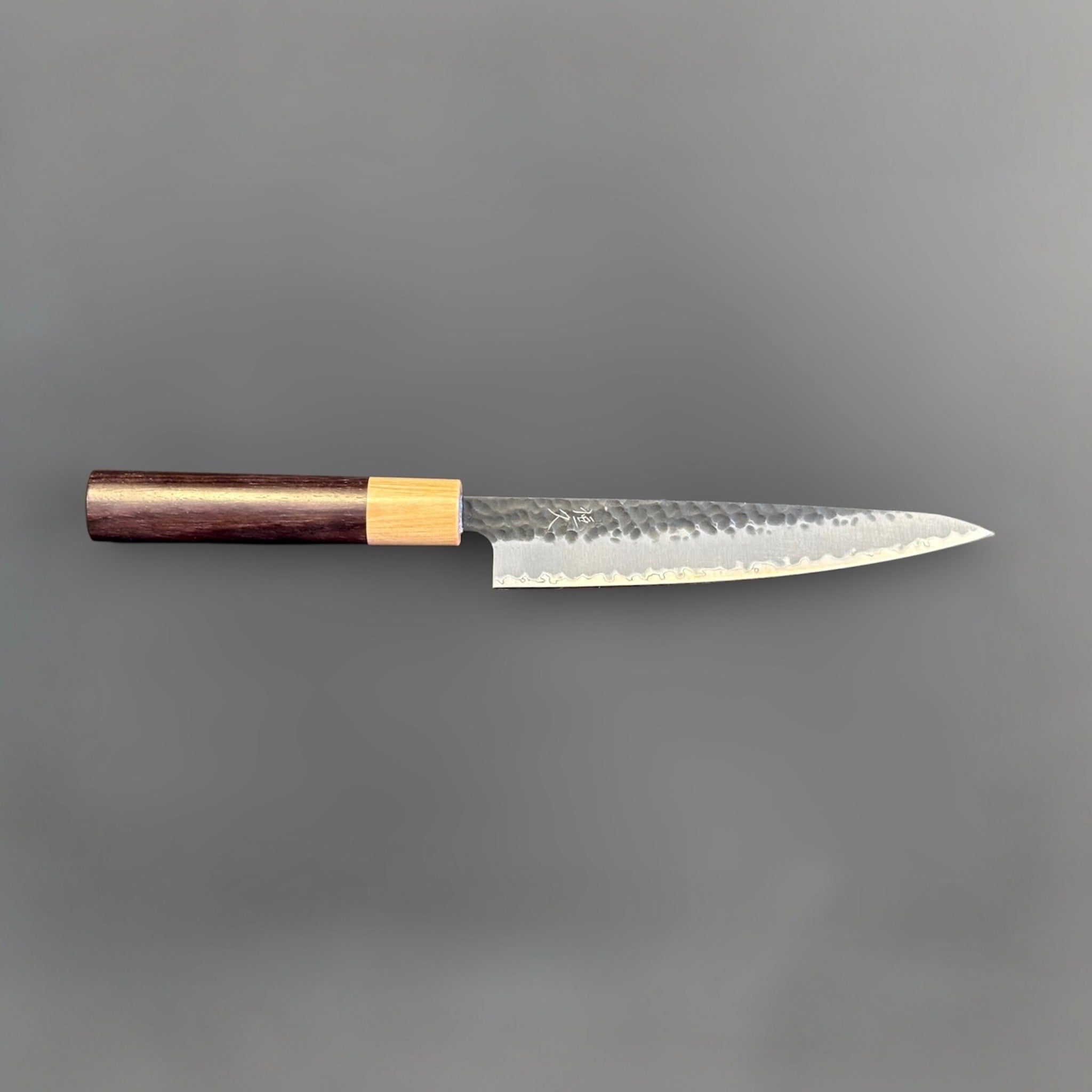 Tsunehisa Aogami Super Tsuchime Kuro Petty 150 mm with morado handle, full profile showing the compact petty shape, kurouchi tsuchime finish, and two-tone wooden handle.