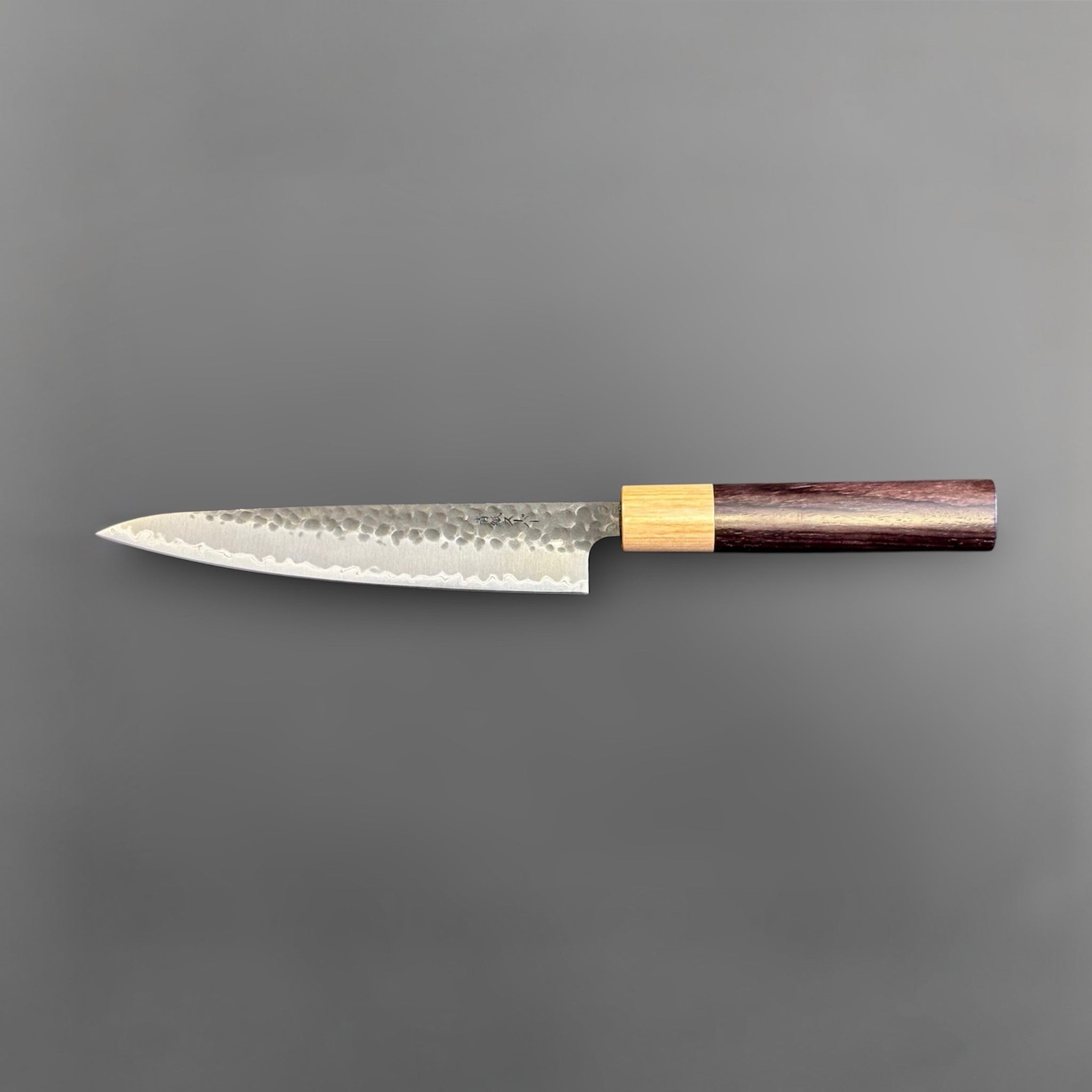 Tsunehisa Aogami Super Tsuchime Kuro Petty 150 mm with morado handle, full reverse-side profile emphasizing the narrow pointed blade and hammered blacksmith finish.