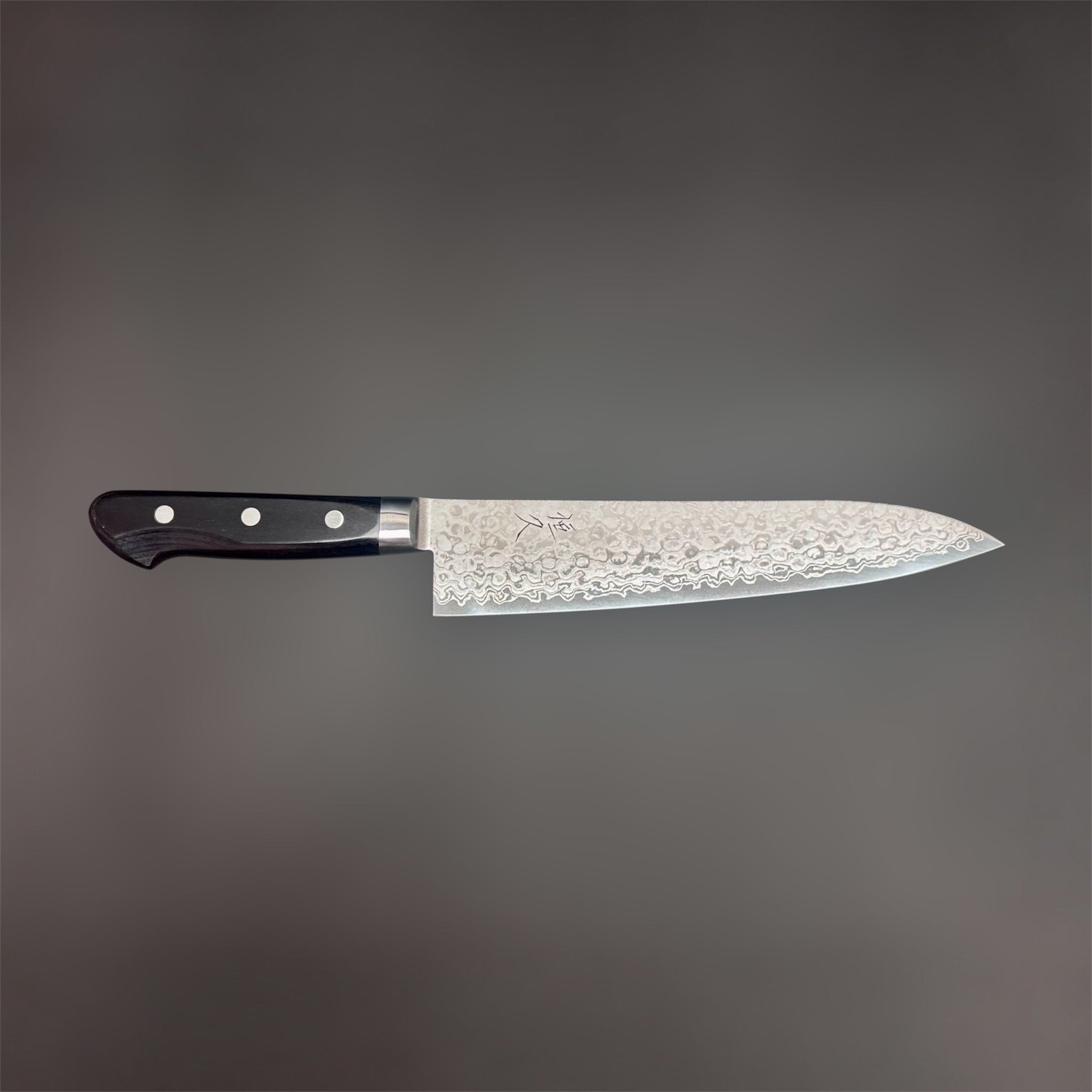 Tsunehisa AUS-10 Damascus Gyuto 210 mm, side profile view with the full knife laid horizontally against a gray background.