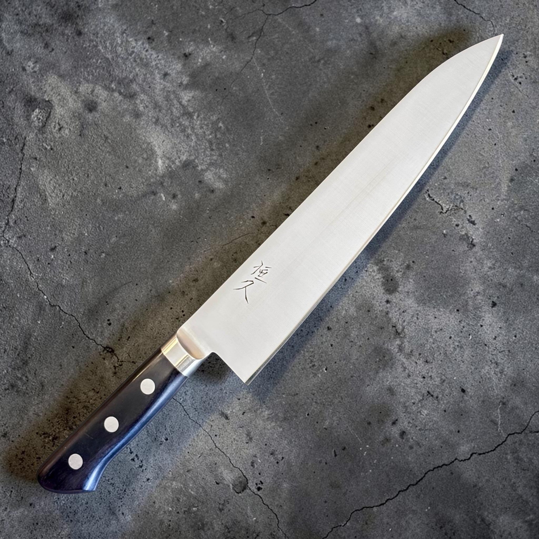 Tsunehisa Mono AUS-8 Gyuto 210 mm with black Western handle, angled full knife view showing the blade face, kanji, and black Western handle.