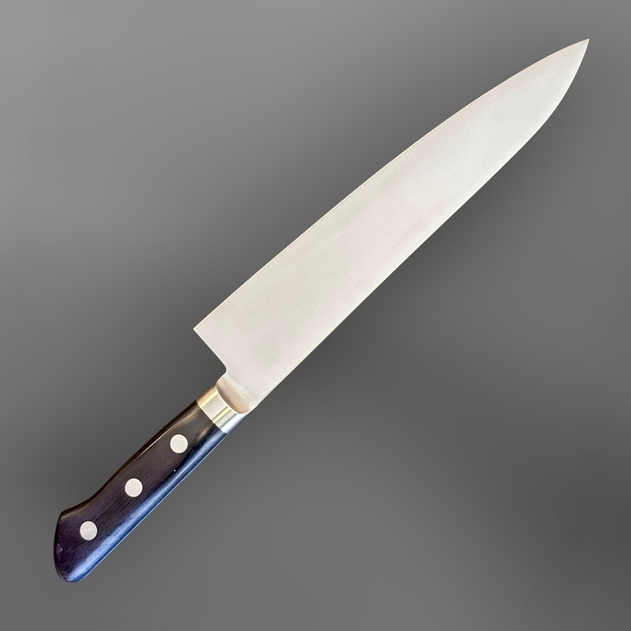 Tsunehisa Mono AUS-8 Gyuto 210 mm with black Western handle, angled full knife view showing the opposite blade face and black Western handle.