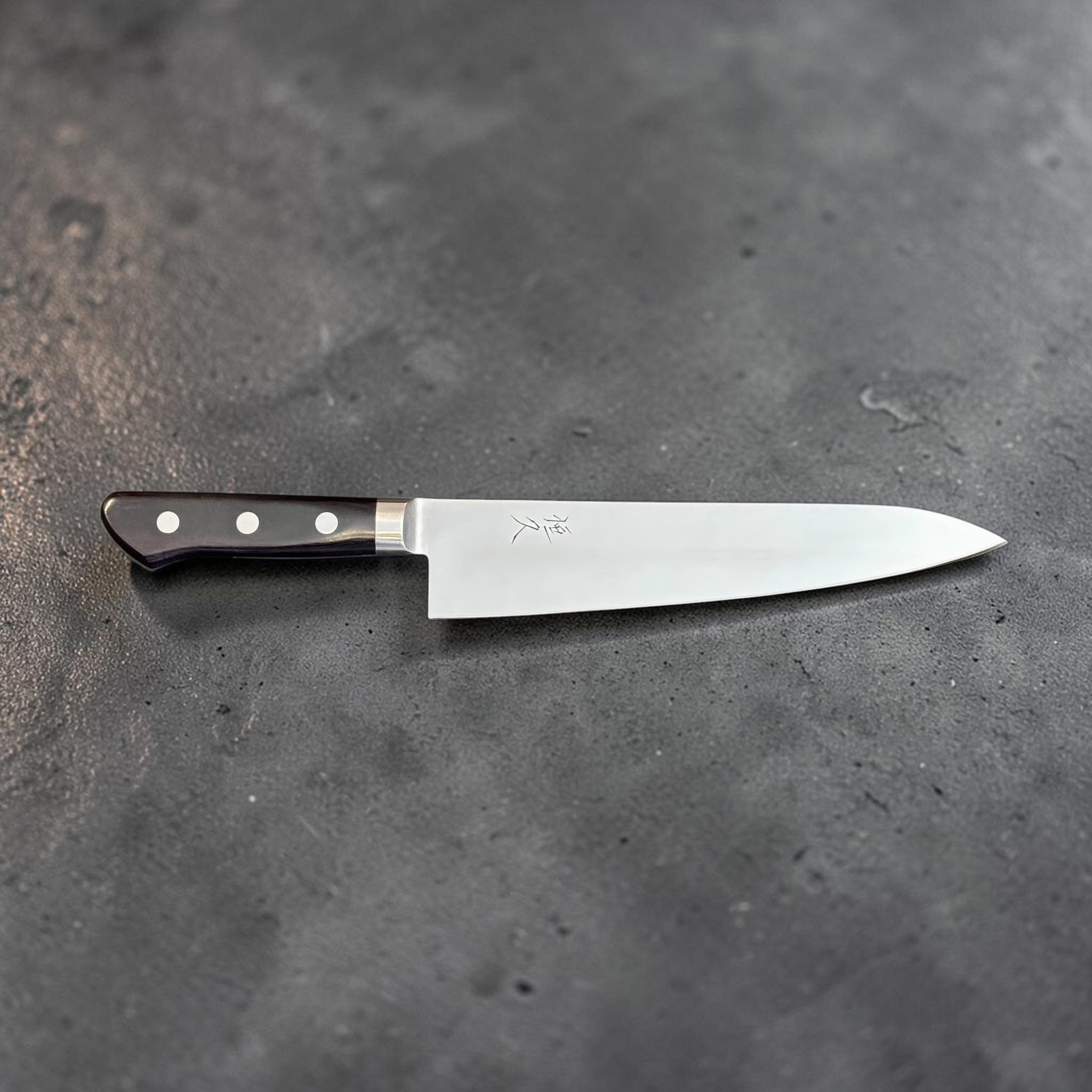 Tsunehisa Mono AUS-8 Gyuto 210 mm with black Western handle, straight side profile showing the gyuto blade shape, kanji, and black Western handle.