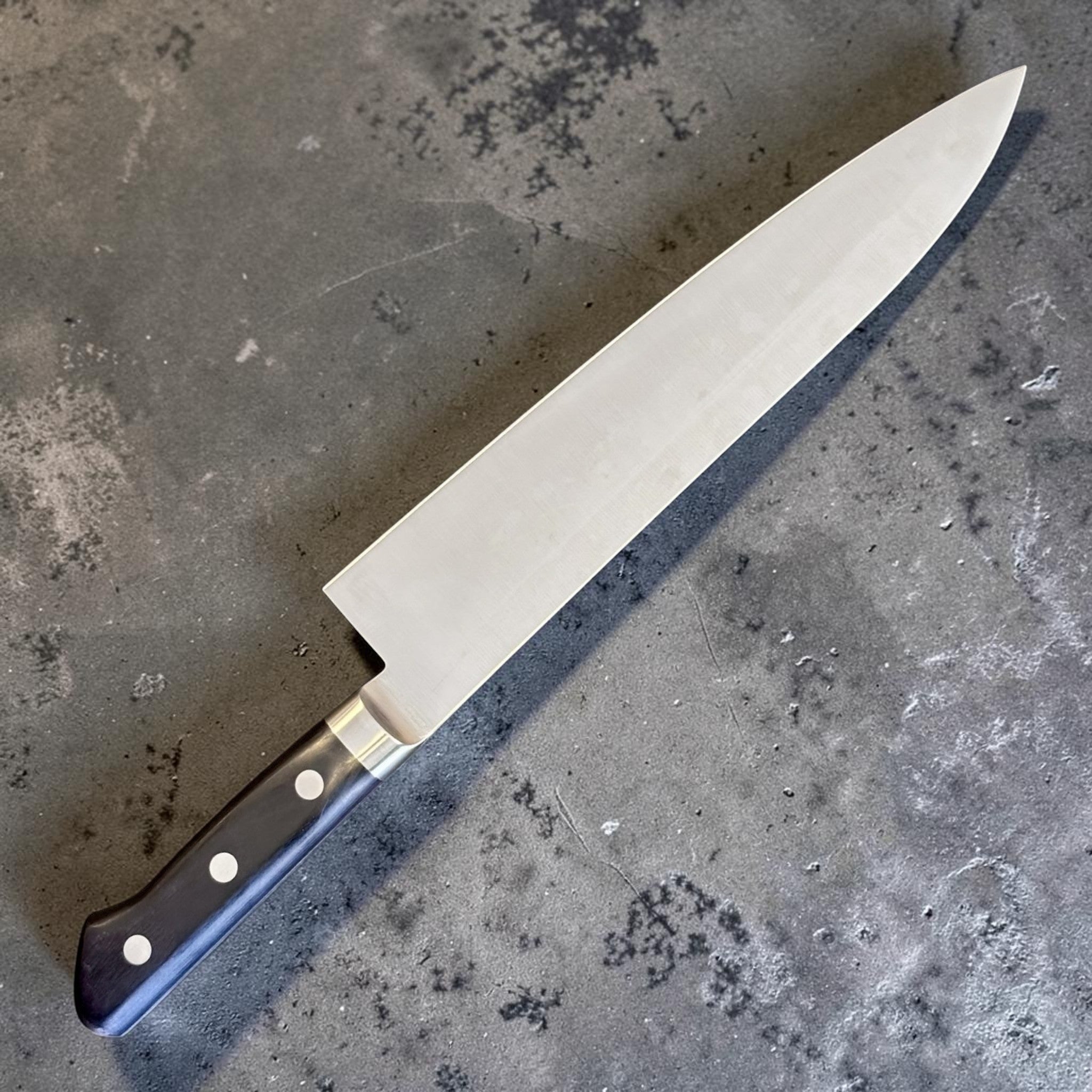 Tsunehisa Mono AUS-8 Gyuto 240 mm with black Western handle, full angled product view on gray background.