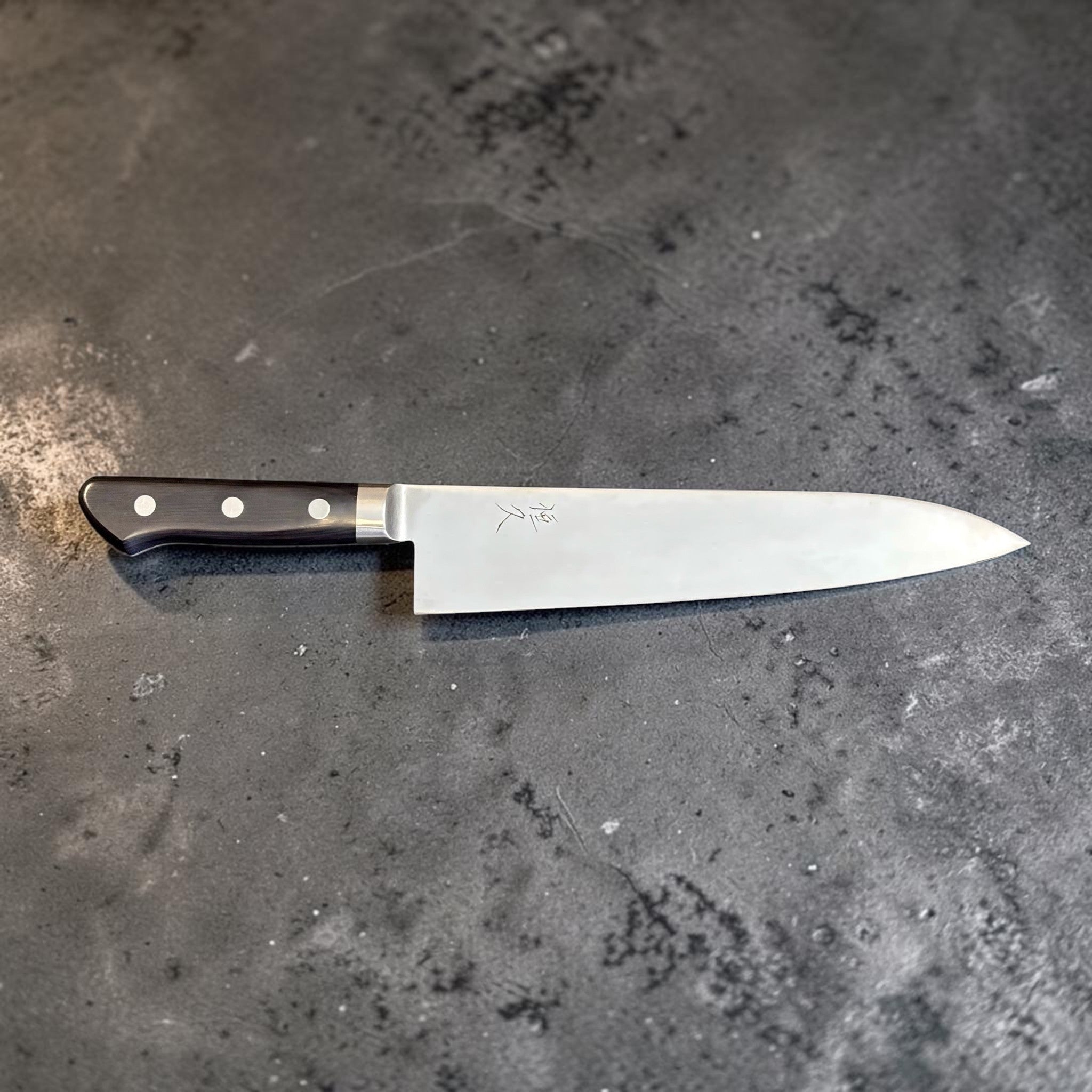 Tsunehisa Mono AUS-8 Gyuto 240 mm with black Western handle, left-facing full blade profile with kanji visible.