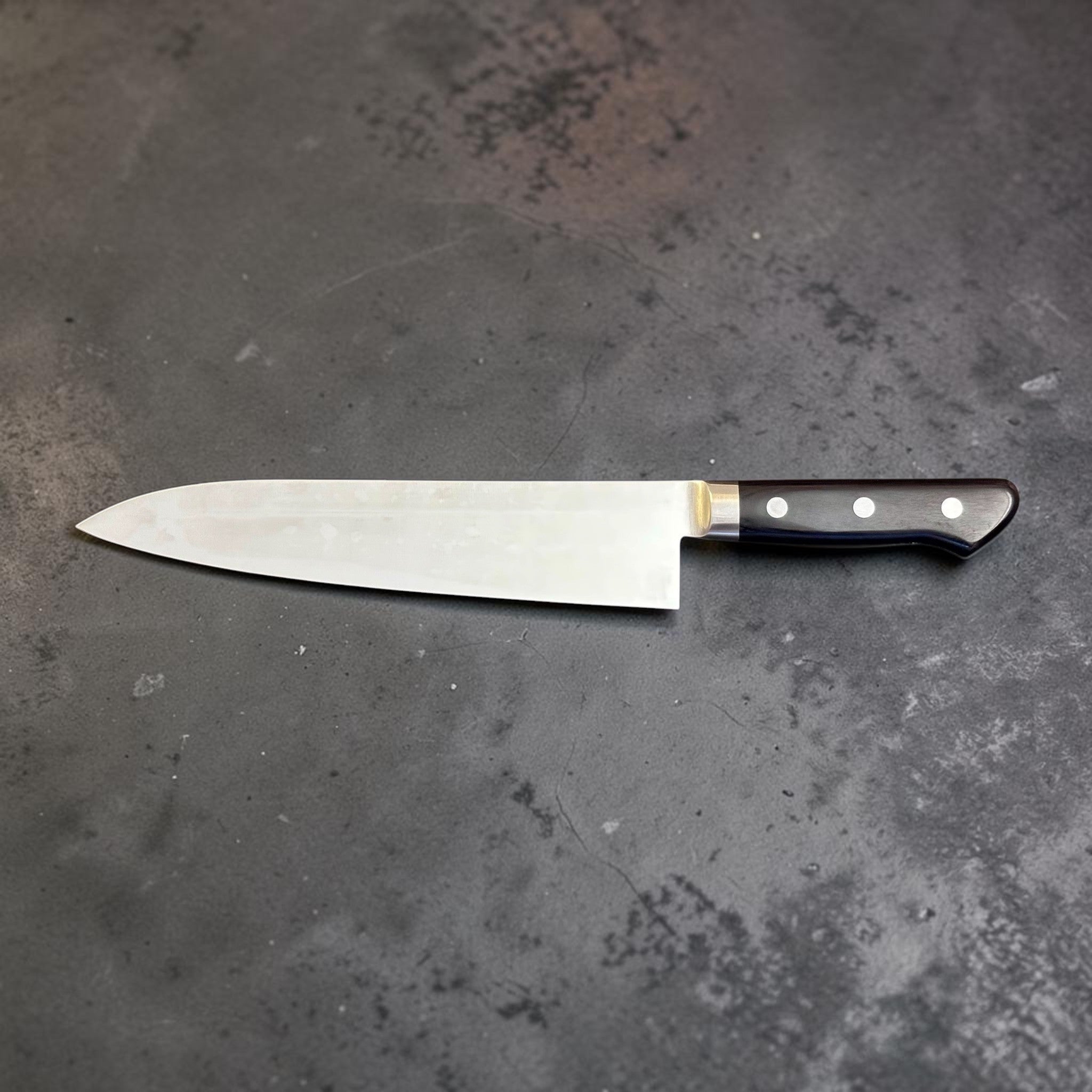 Tsunehisa Mono AUS-8 Gyuto 240 mm with black Western handle, right-facing full blade profile showing black Western handle.