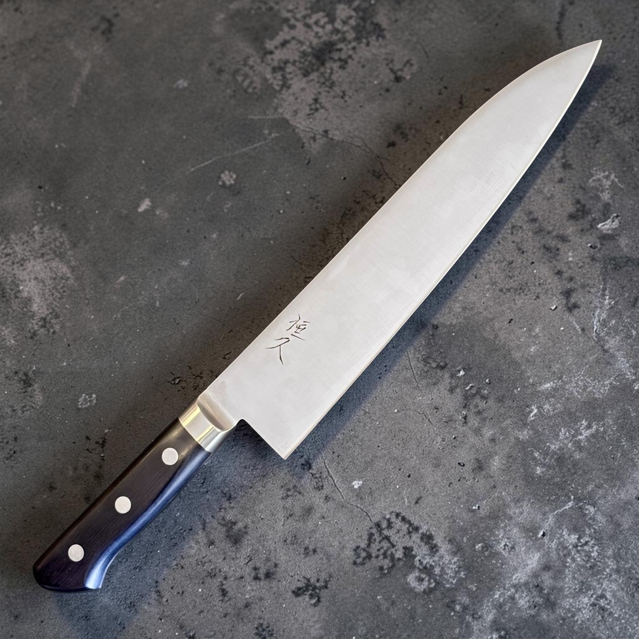 Tsunehisa Mono AUS-8 Gyuto 240 mm with black Western handle, angled product view highlighting black Western handle and stainless blade.