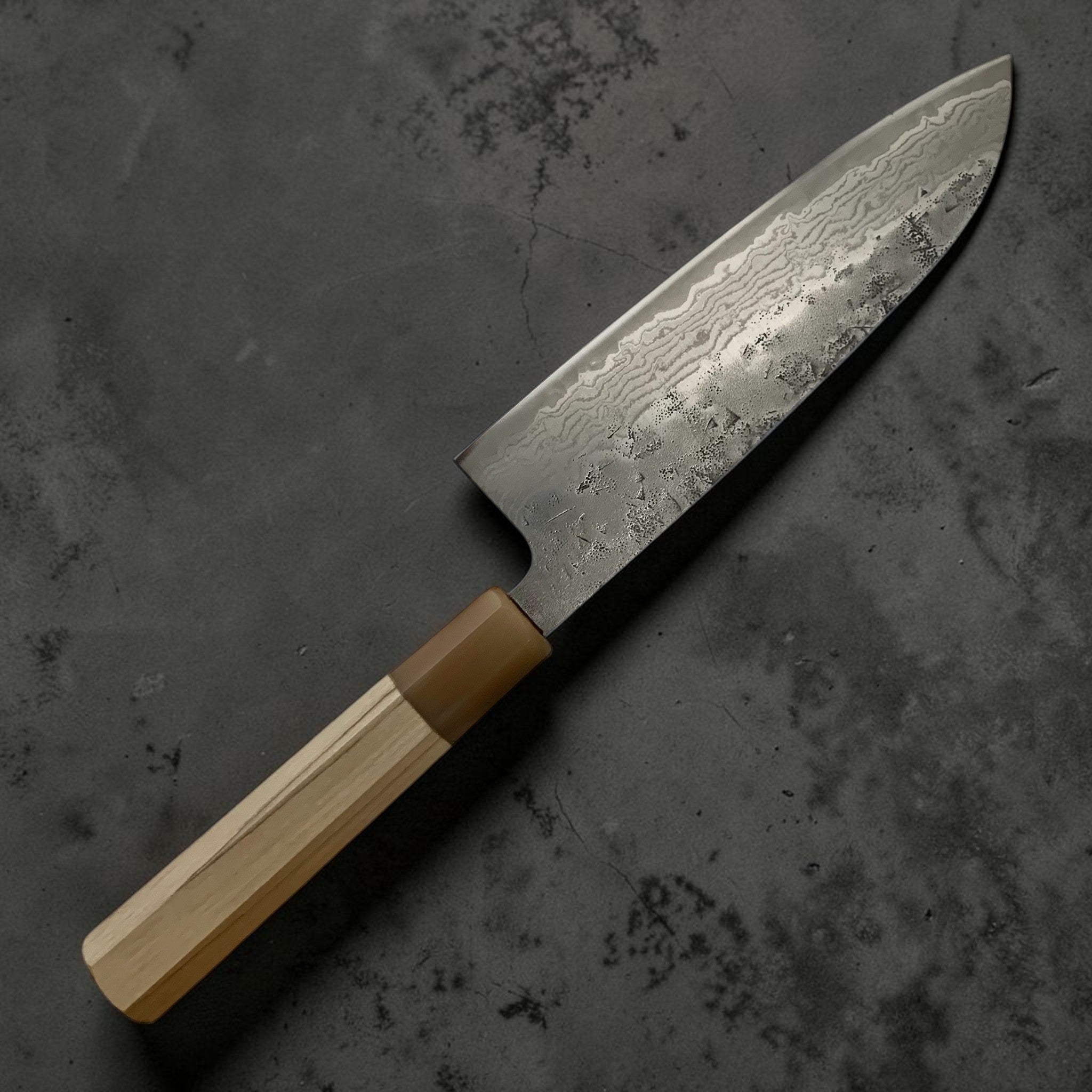 Tsunehisa Swedish Steel Washiji Damascus Santoku 170 mm, left-handed view highlighting forged texture and wave pattern.