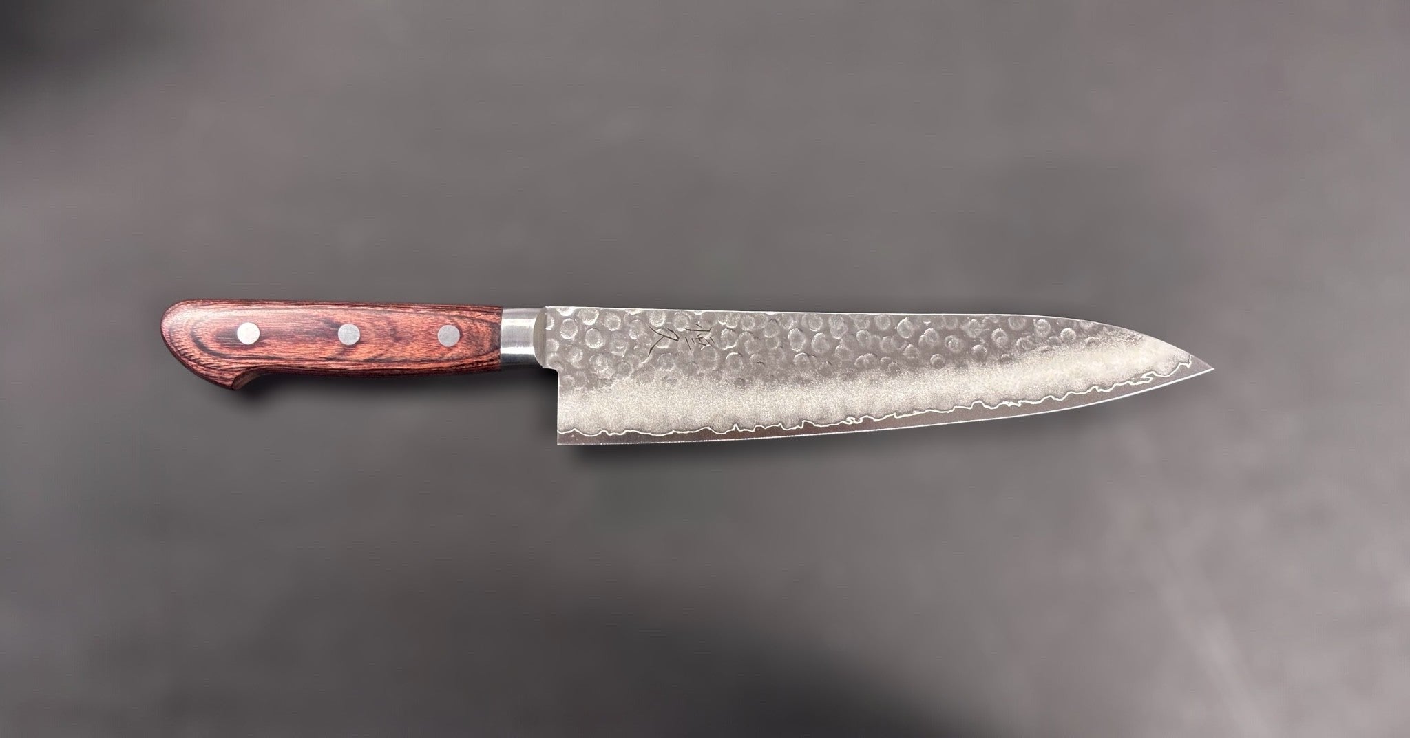 Tsunehisa VG-10 Tsuchime Gyuto 210 mm with brown Western handle, full side profile on dark backdrop (landscape orientation).