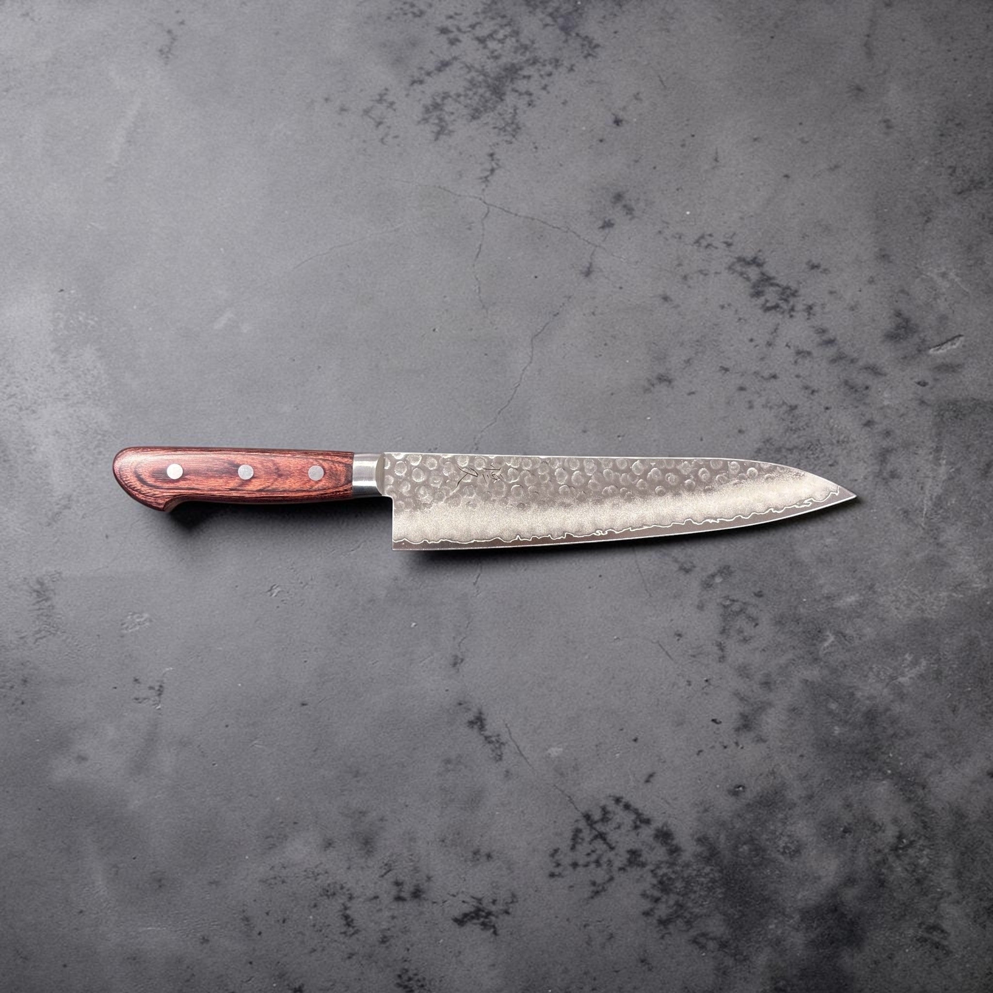Tsunehisa VG-10 Tsuchime Gyuto 210 mm with brown Western handle, full side profile on dark backdrop (landscape orientation).